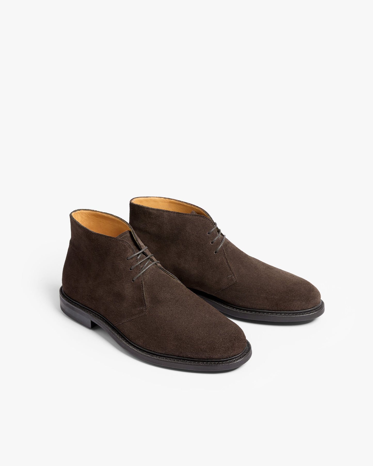 Gyllsjö II in dark brown suede displayed at a three-quarter angle, featuring soft suede uppers, understated stitching, and a classic chukka boot silhouette with a softly chiseled toe and black sole.