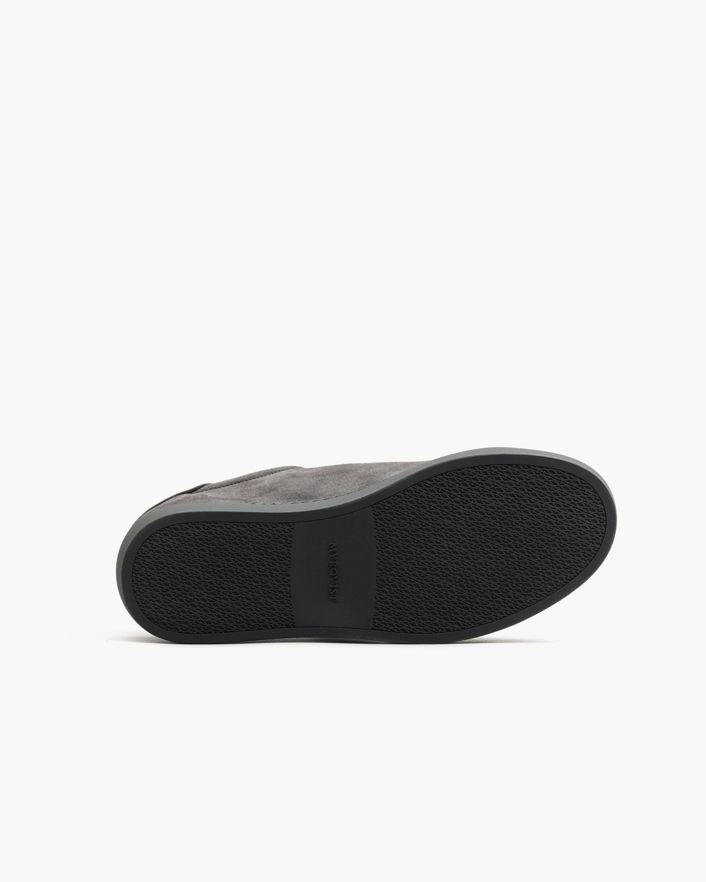 Oaxen Monochrome in dark grey suede shown with the sole facing up, highlighting the textured M-pattern grip and seamless transition between the upper and outsole.