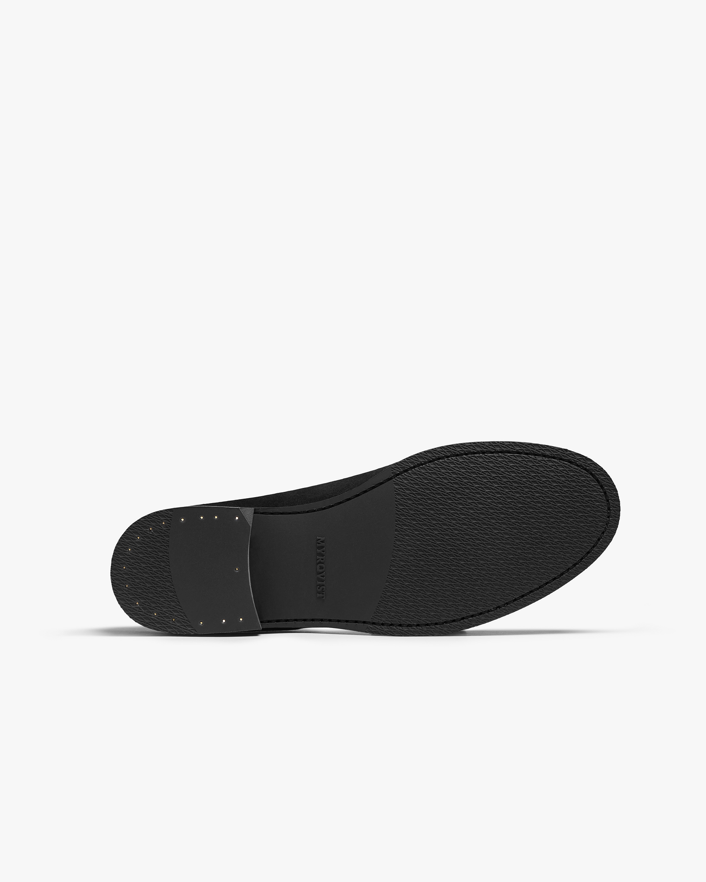 Close-up of the sole of Karlberg in dark brown suede, featuring a textured black rubber sole with subtle stitching and a stacked heel for durability and grip.