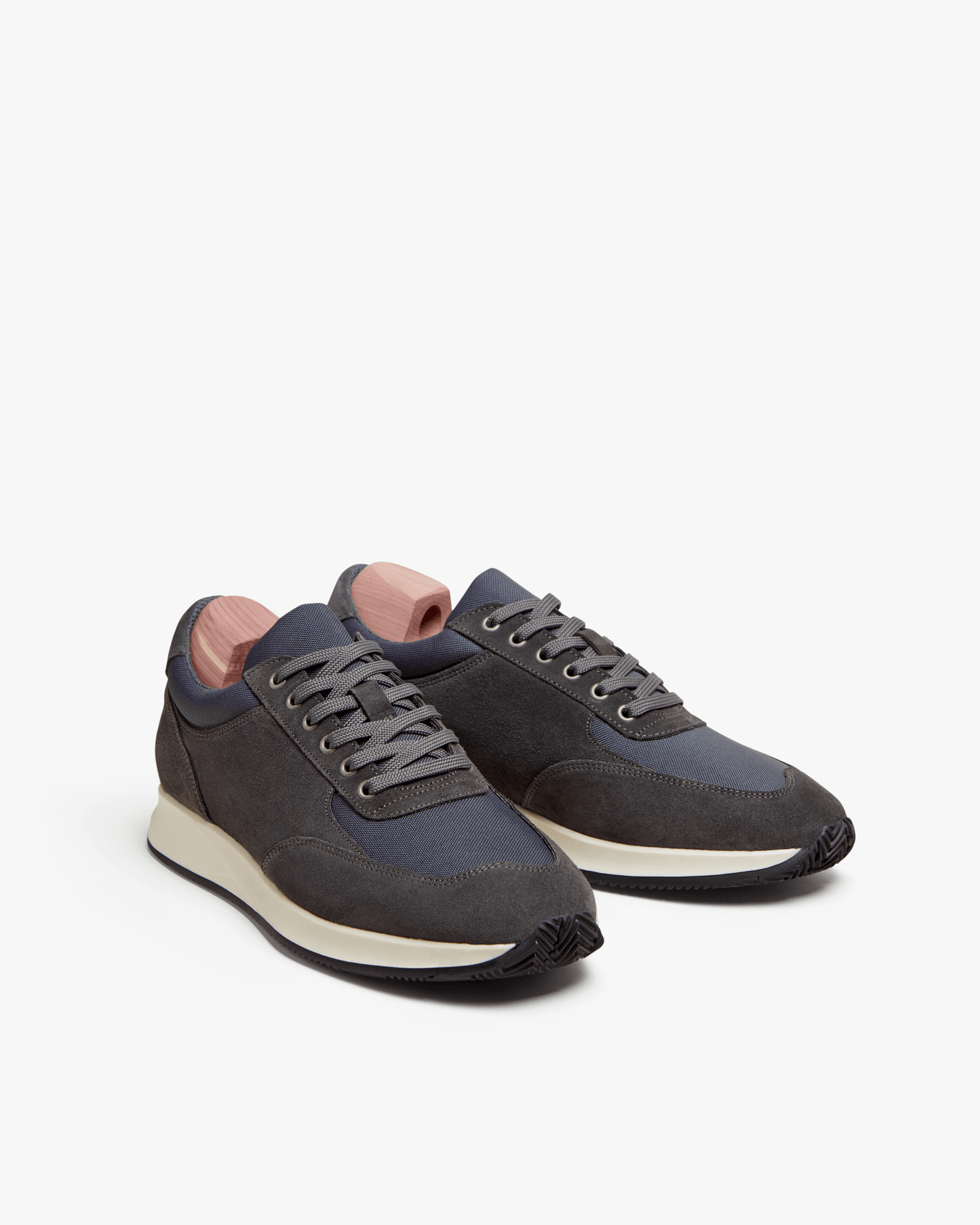 Stensund in dark grey suede features a modern low-top silhouette with tonal mesh panels, lace-up closure, and contrasting off-white rubber soles, blending athletic comfort with understated Scandinavian style.