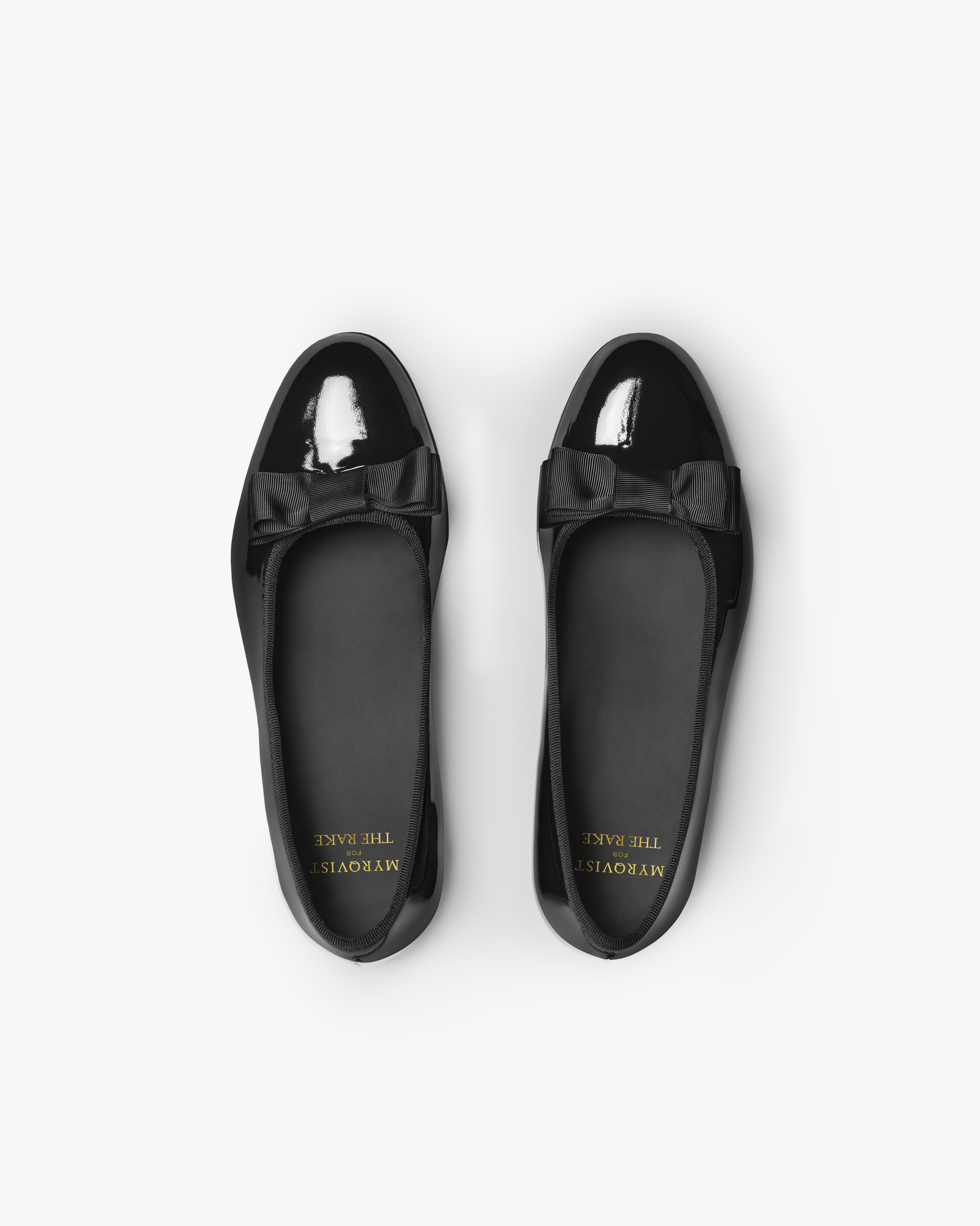Rosendal in black patent leather shown from above, highlighting the glossy finish, almond-shaped toe, and elegant grosgrain bow detail, ideal for formal eveningwear and pairing with tailored trousers or tuxedos.