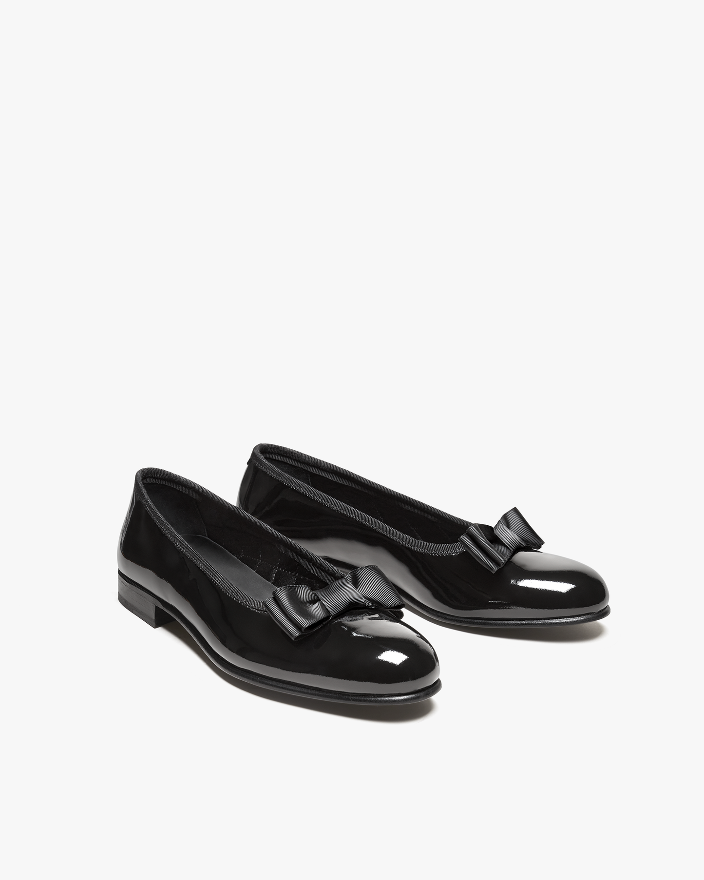 Rosendal in black patent leather features a glossy opera pump silhouette with an almond-shaped toe and grosgrain bow, designed for formal occasions and pairing with tuxedos or tailored evening suits.