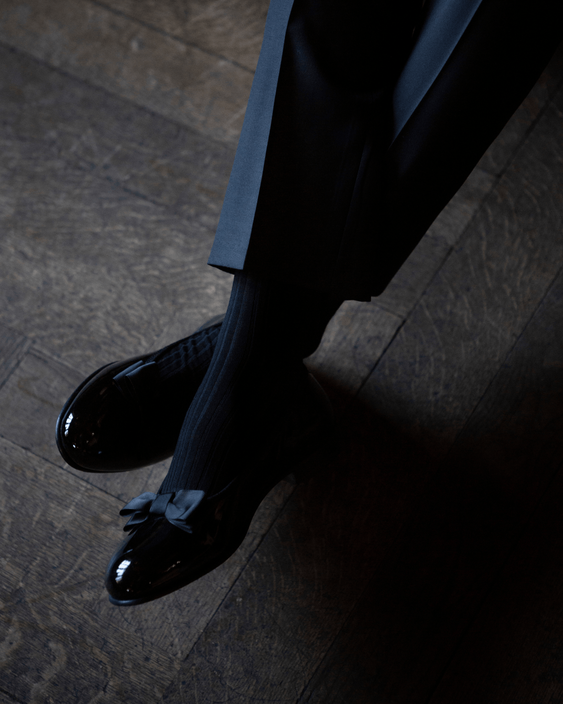 Rosendal in black patent leather worn with dark socks and tailored trousers, featuring a high-gloss finish and grosgrain bow, ideal for formal eveningwear and black tie events.