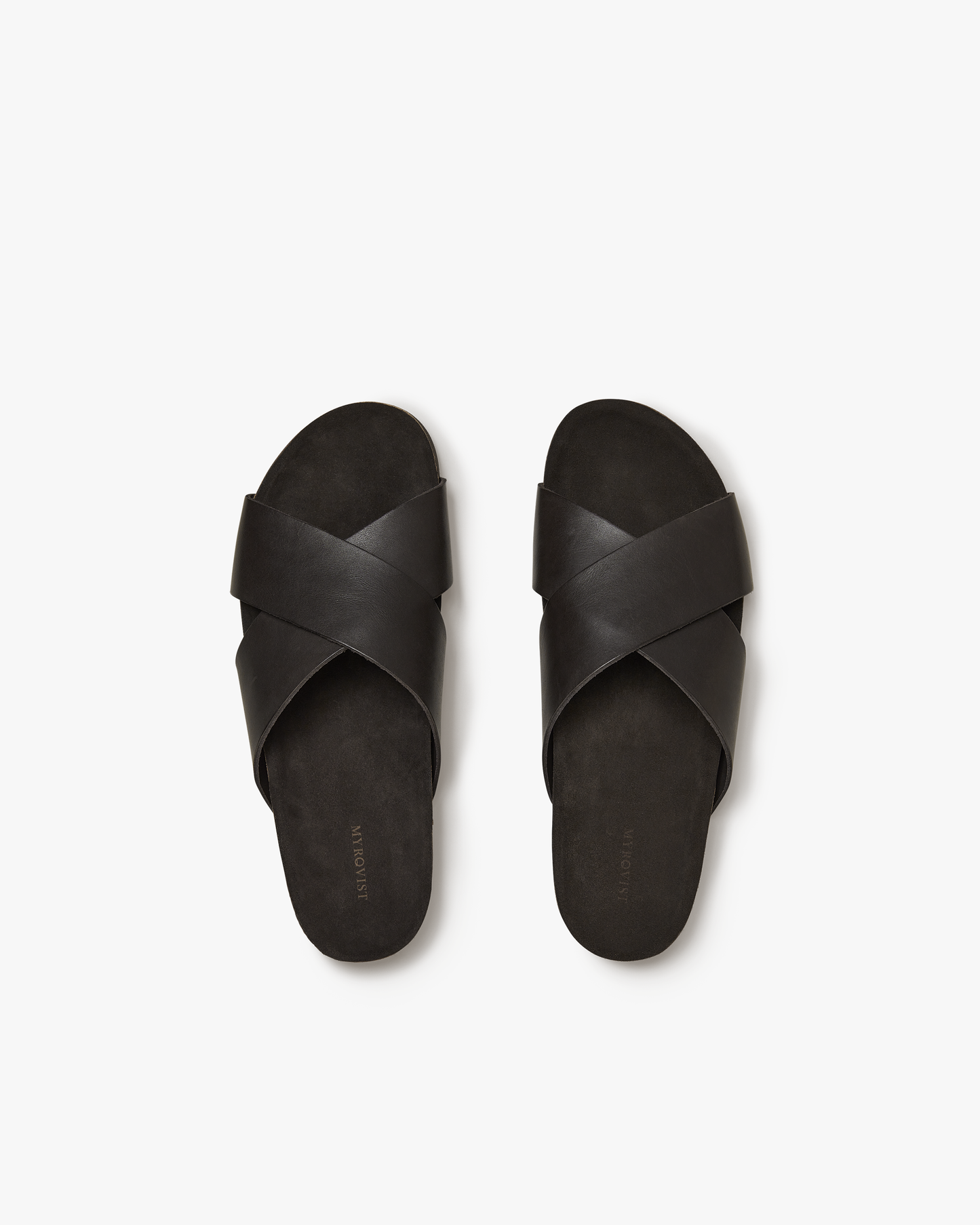 Solvik in dark brown calf features wide, criss-crossed leather straps and a contoured footbed, shown from above to highlight the sandal’s minimal silhouette and comfortable suede insole.