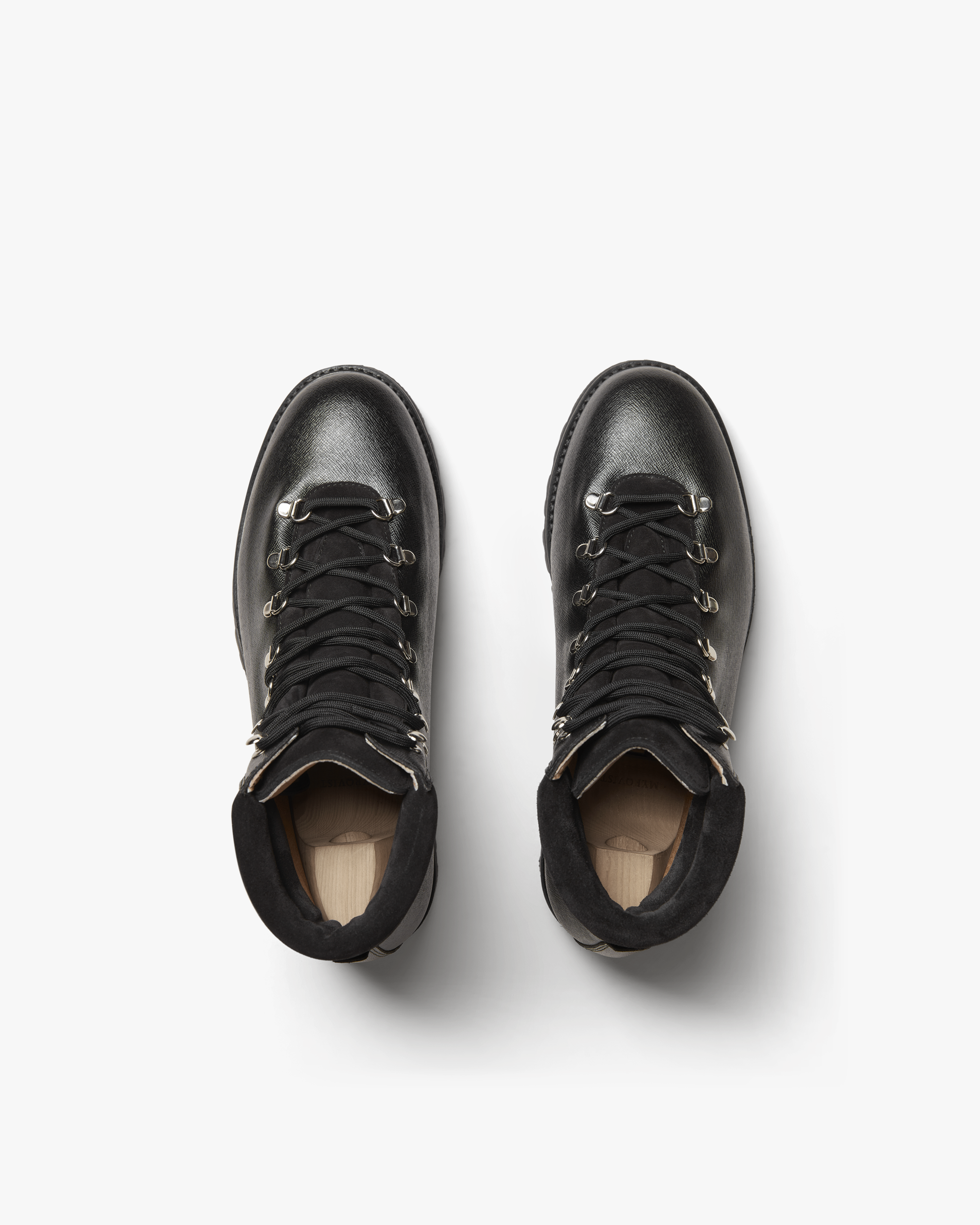 Duved in black grain calf shown from above, highlighting the textured leather, secure lacing system, padded collars, and silver-toned hardware for a refined hiking boot style.