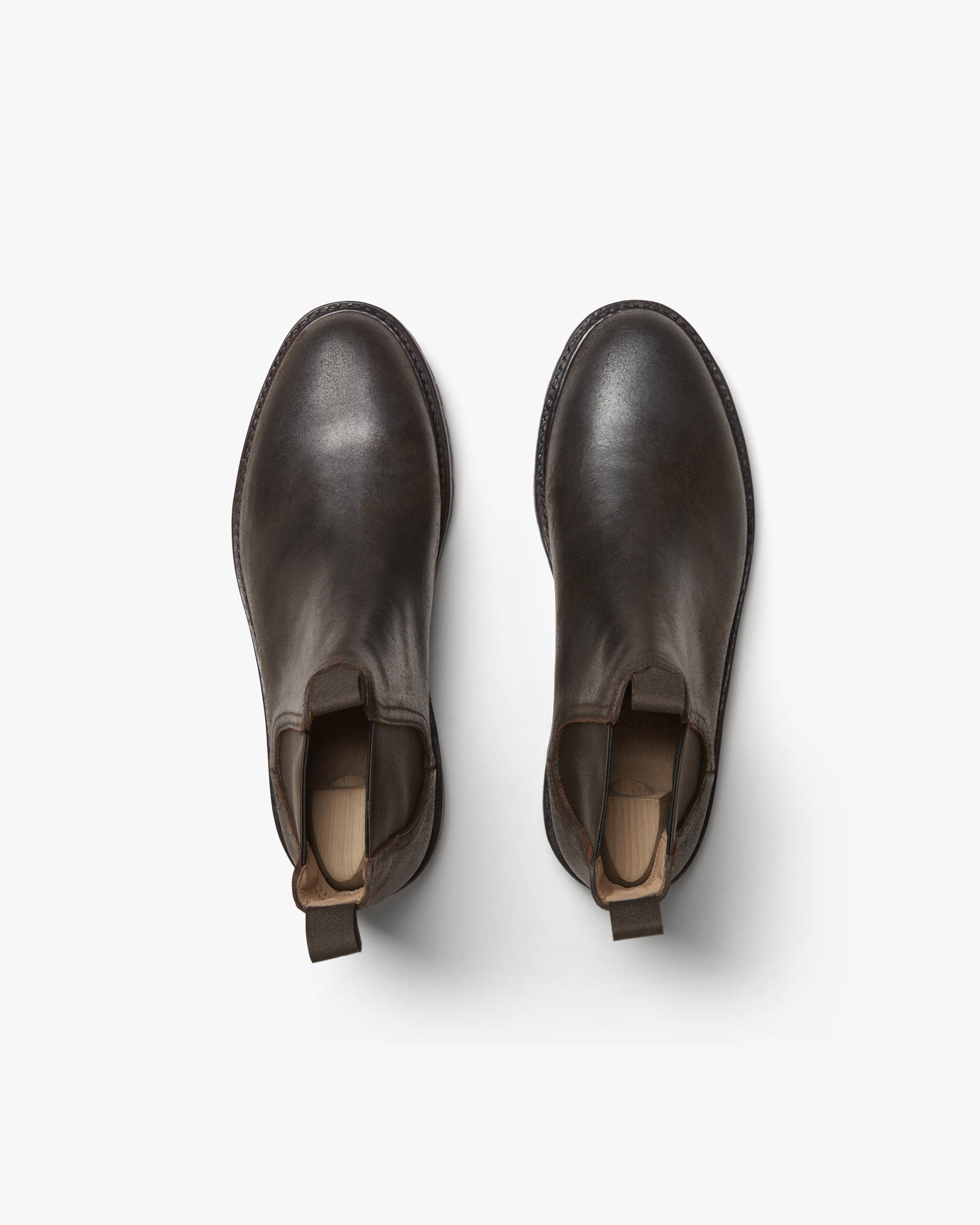 Elfvik in brown waxed suede shown from above, highlighting the smooth matte finish, rounded toe, and pull tabs on each Chelsea boot.