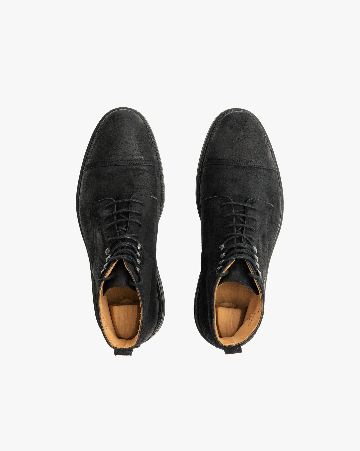 Abisko in black waxed suede shown from above, highlighting the matte black cap toe boots with lace-up closure, subtle stitching, and tan leather lining.