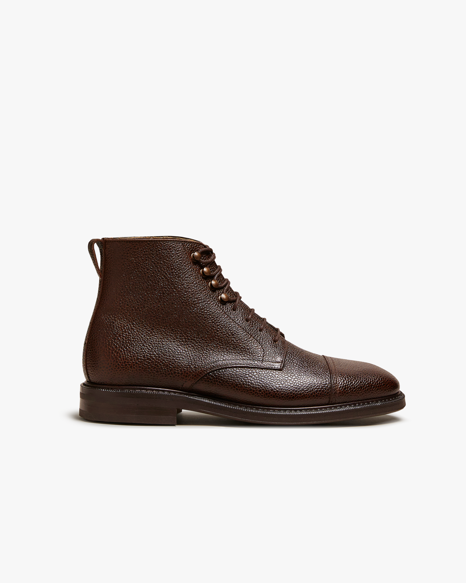 Abisko in dark brown country calf features a textured grained leather upper, cap toe detailing, and sturdy lace-up closure, set on a robust rubber sole for versatile wear in both city and outdoor settings.
