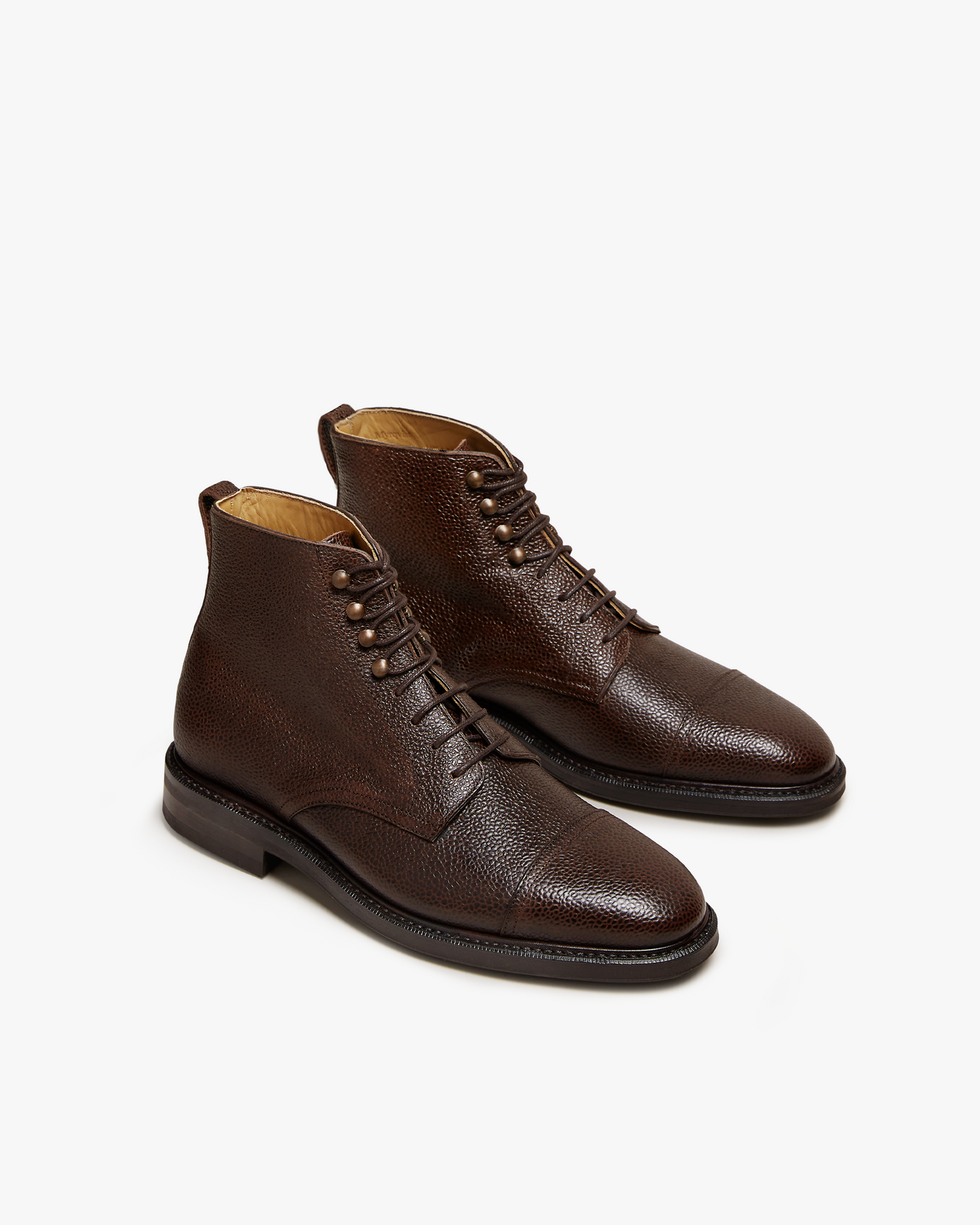 Abisko in dark brown country calf features a textured grained leather upper, cap toe design, and sturdy lace-up closure with metal eyelets, offering a refined and versatile boot for both casual and tailored looks.
