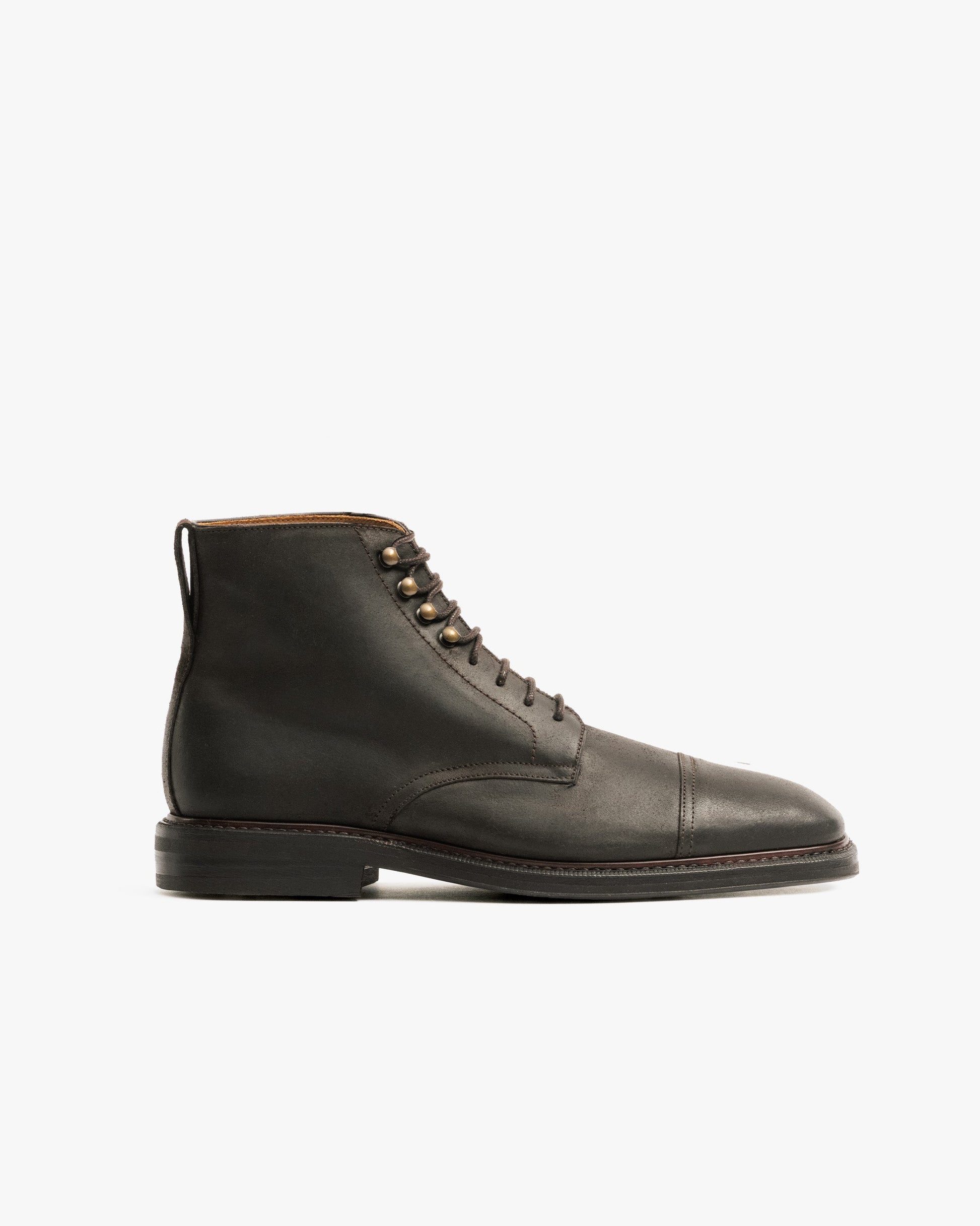 Abisko in brown waxed suede features a lace-up design with a rounded toe, cap detail, and sturdy double studded rubber sole, showcasing its water-resistant finish and subtle patina for versatile winter wear.