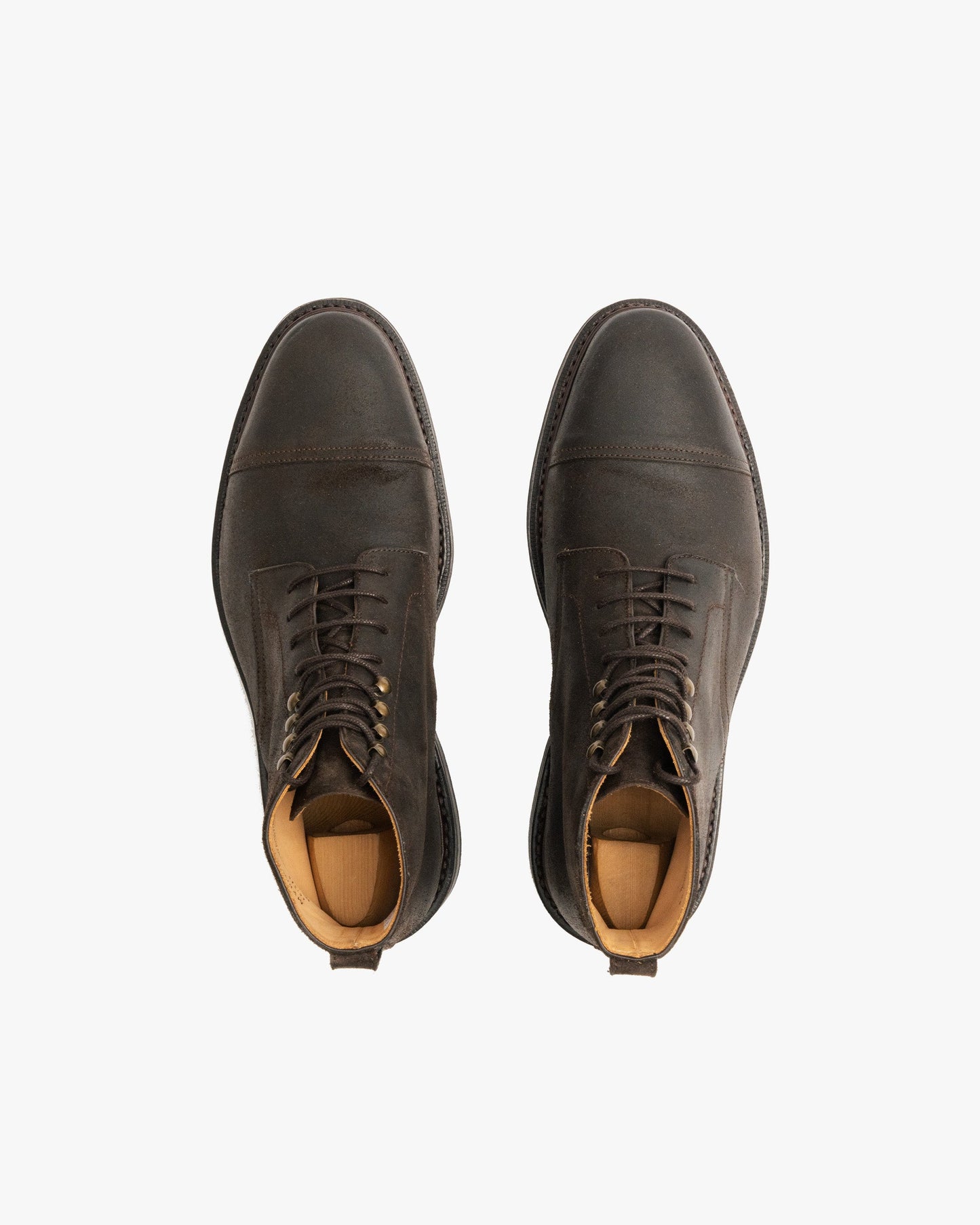 Abisko in brown waxed suede shown from above, highlighting the rounded toe, cap detail, lace-up design, and subtle weathered patina with wooden shoe trees inside.