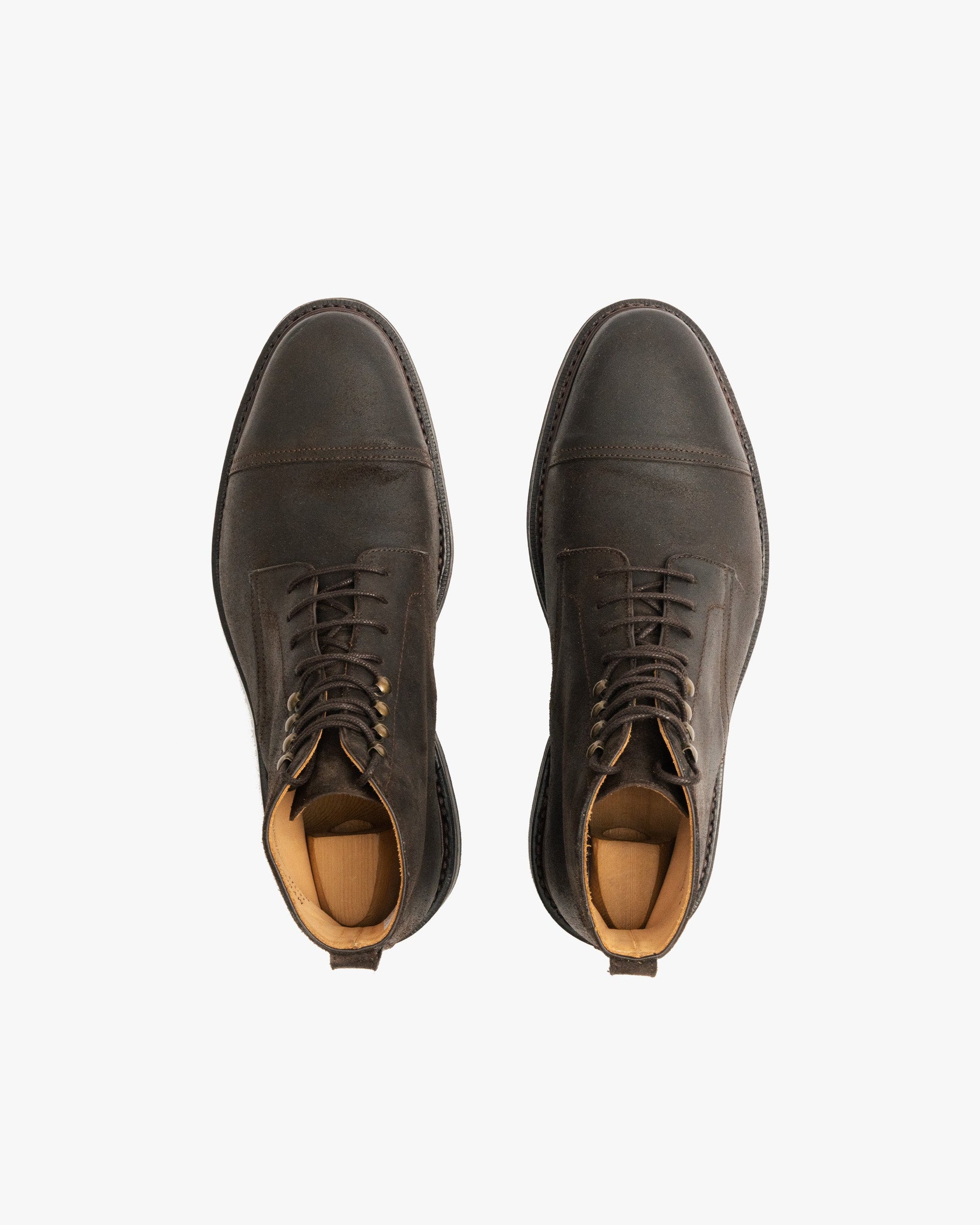 Abisko in brown waxed suede shown from above, highlighting the rounded toe, cap detail, lace-up design, and subtle weathered patina with wooden shoe trees inside.