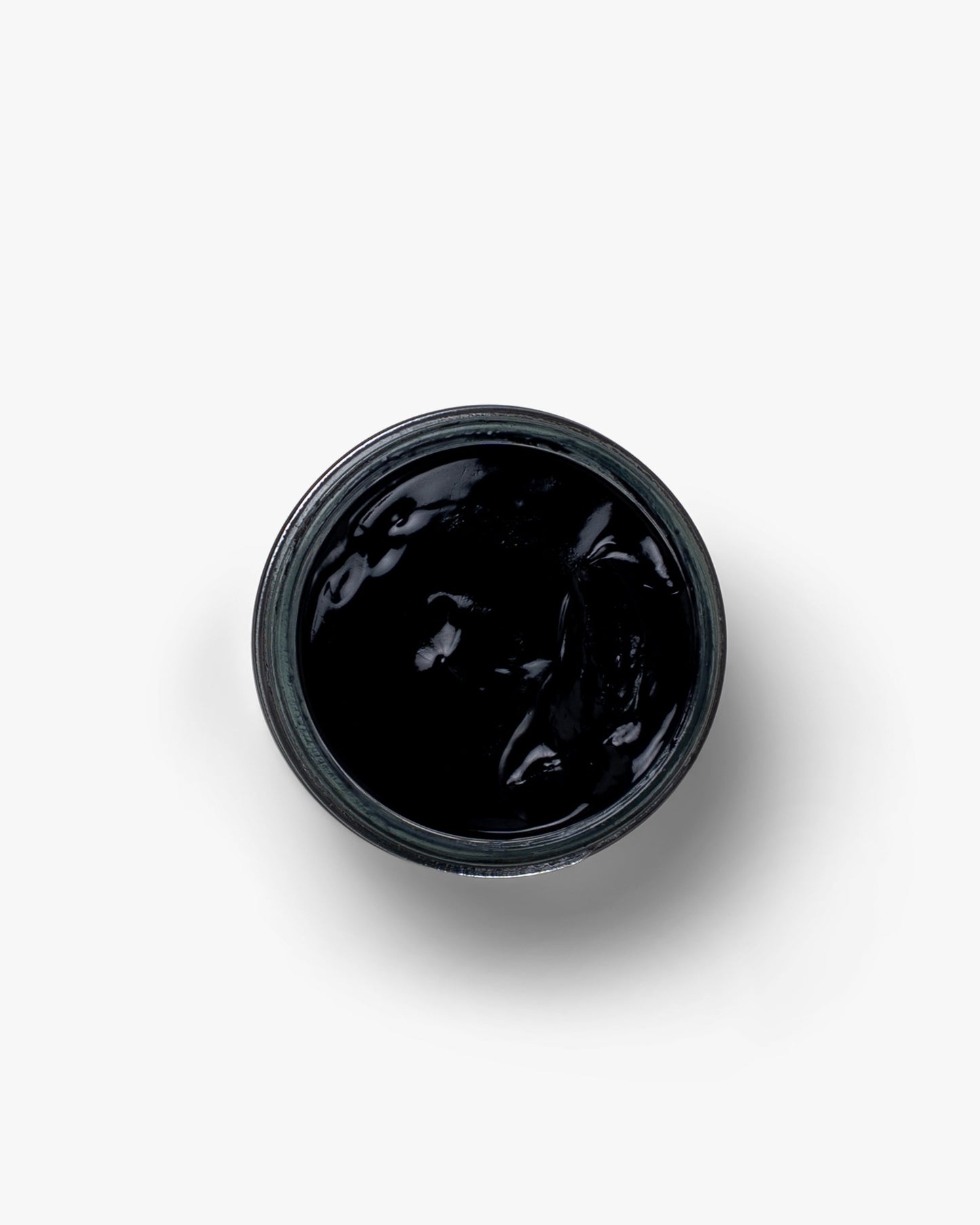 A jar of Myrqvist Shoe Cream in black, displaying its rich, creamy texture ideal for conditioning and enhancing the finish of leather footwear.