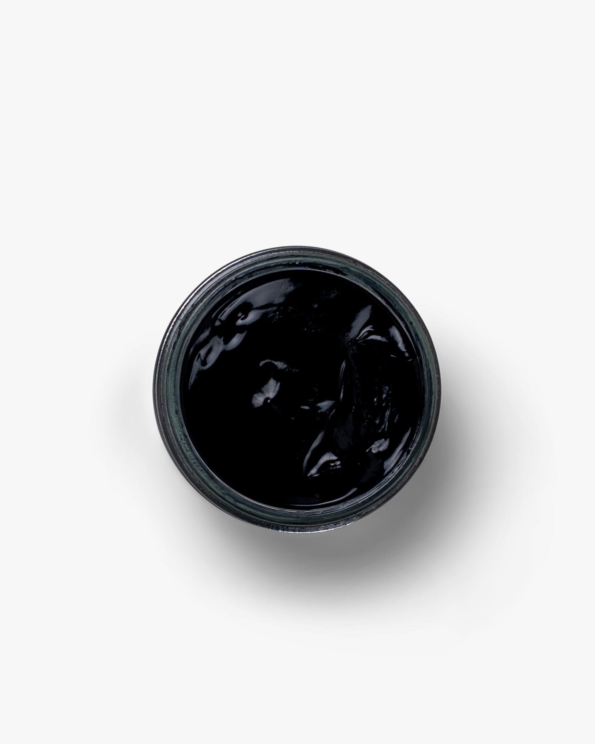 A jar of Myrqvist Shoe Cream in black, displaying its rich, creamy texture ideal for conditioning and enhancing the finish of leather footwear.
