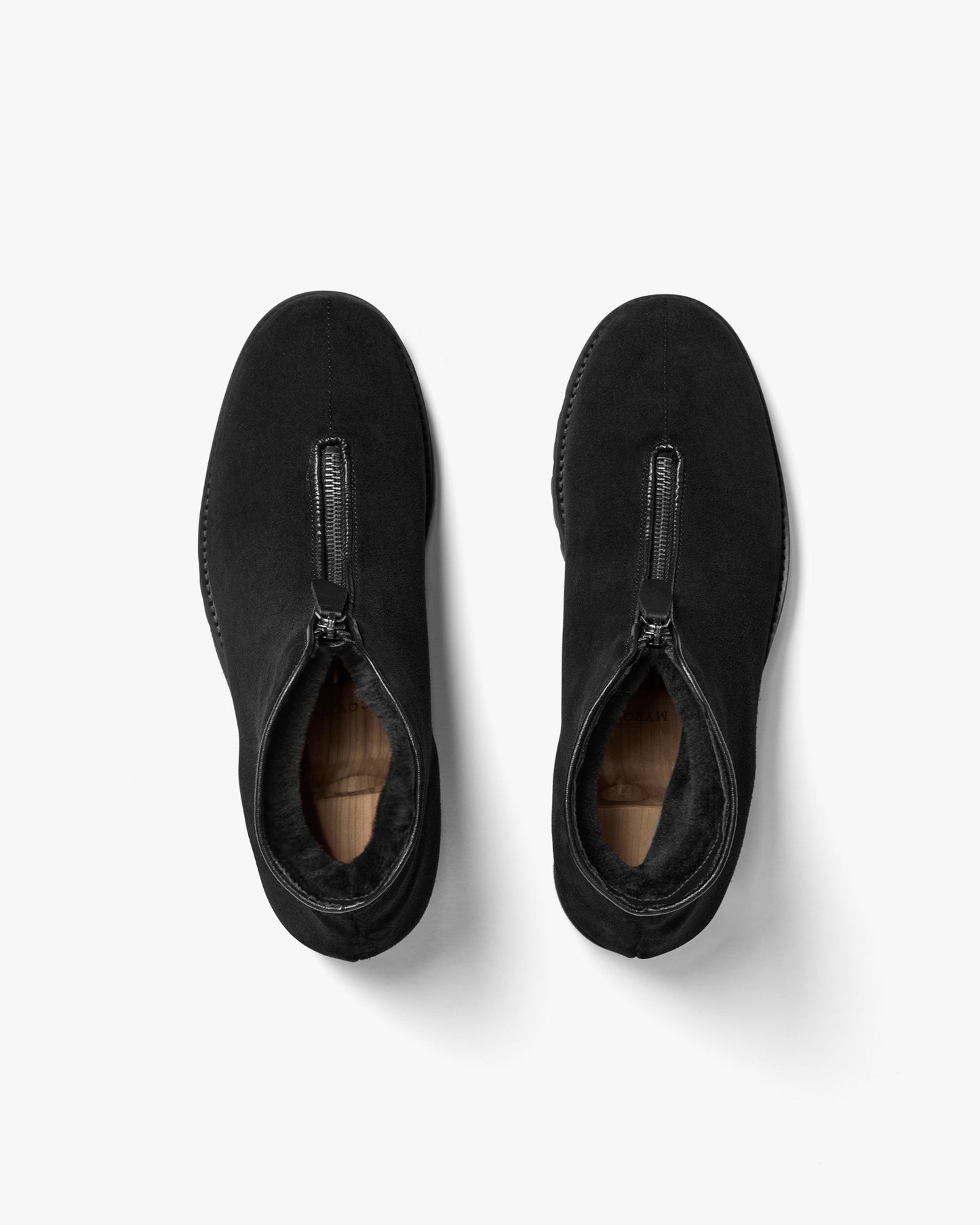 Funäs in black suede shown from above, highlighting the central zipper, plush shearling lining, and the smooth, water-repellent suede upper designed for winter comfort and style.