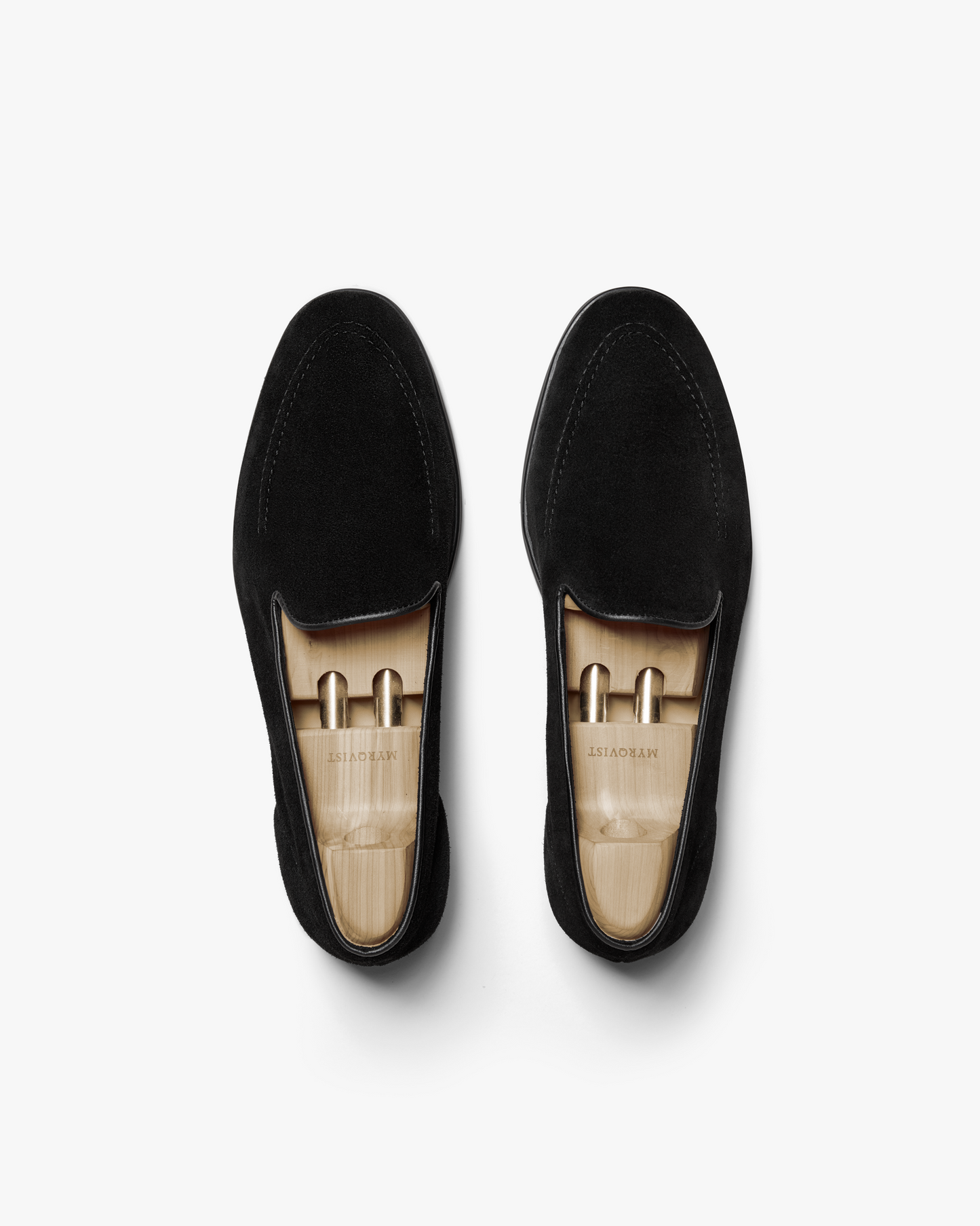 Brännö II in black suede shown from above, highlighting the minimalist loafer design with clean stitching, full leather lining, and wooden shoe trees inside each shoe.