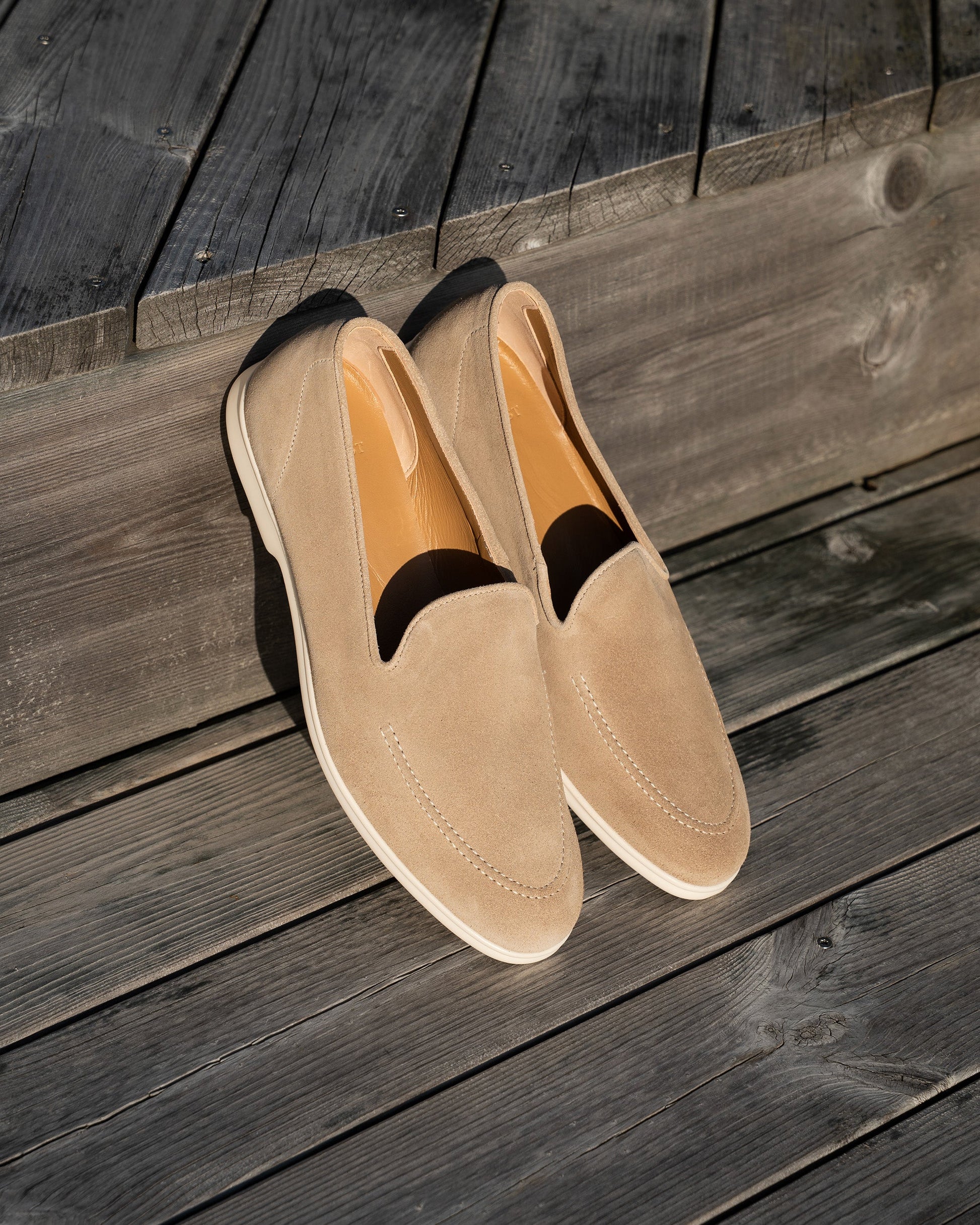 Brännö II in sand suede displayed outdoors on wooden decking, highlighting the soft beige suede upper, clean stitching, and white rubber soles, ideal for relaxed summer occasions.