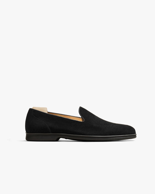 Men’s Brännö II loafer in black suede with a minimalist silhouette, tonal stitching, and a sleek black rubber sole, shown in a side profile against a white background.