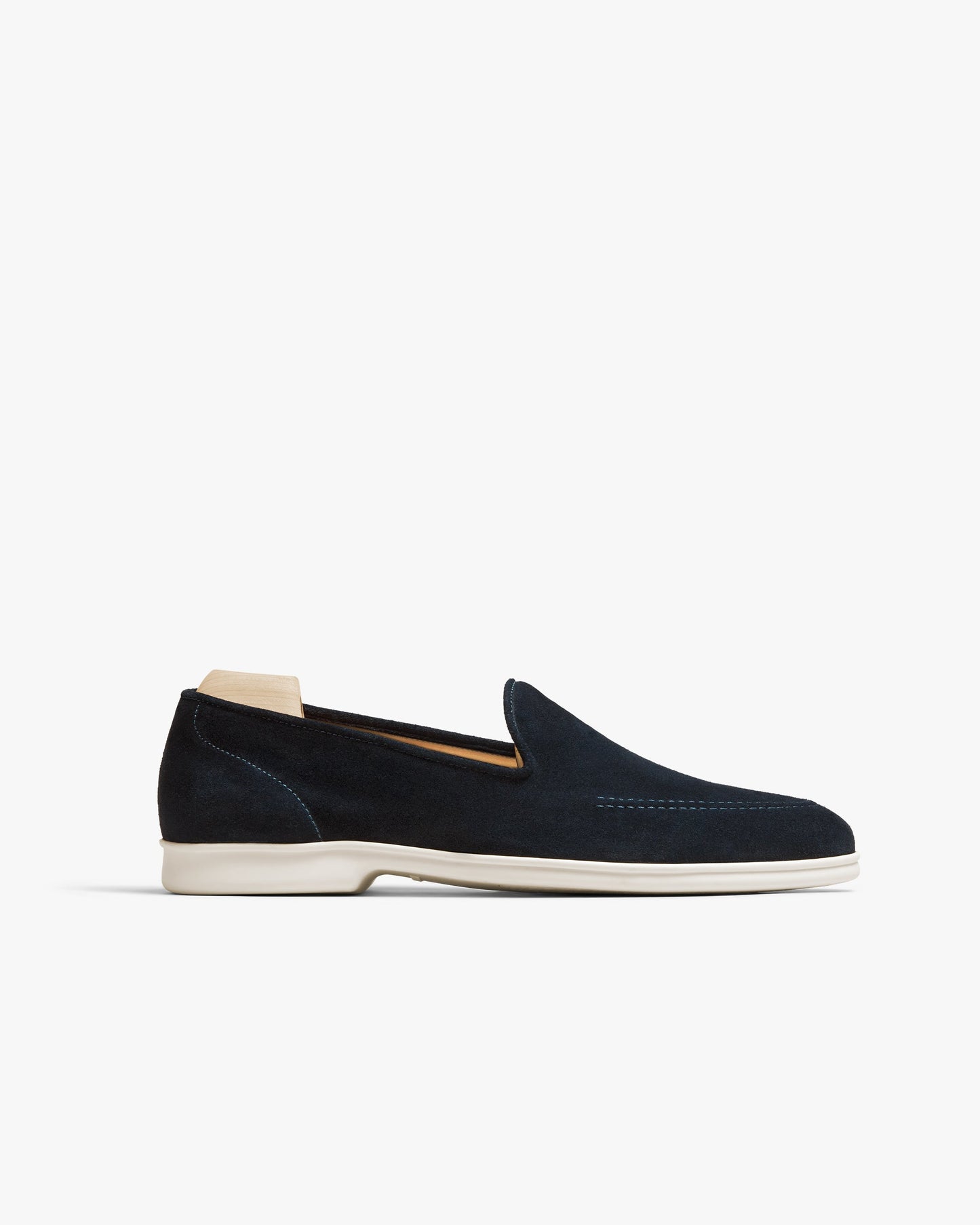 Brännö II in navy suede features a sleek slip-on loafer silhouette with soft suede uppers, tonal stitching, and a contrasting white rubber sole, shown in a side profile against a clean background.