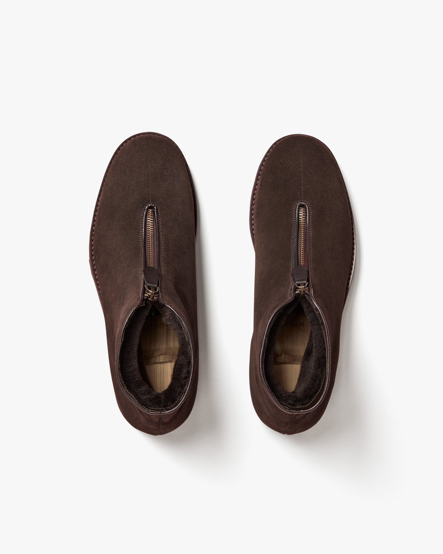 Top view of Funäs in dark brown suede, showing the central zipper closure and plush shearling lining for warmth and comfort. The clean, minimalist design highlights the soft suede texture and practical winter styling.