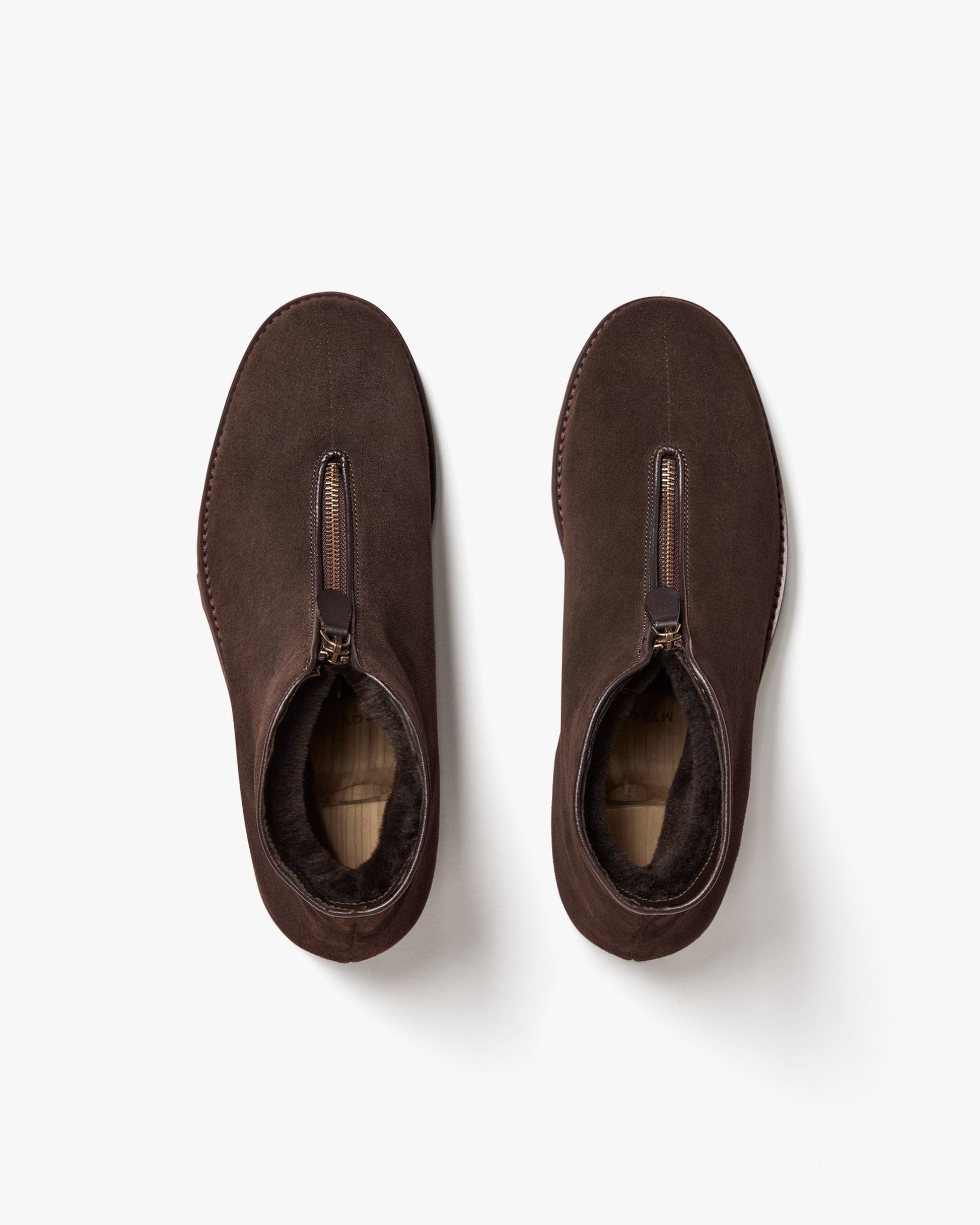 Top view of Funäs in dark brown suede, showing the central zipper closure and plush shearling lining for warmth and comfort. The clean, minimalist design highlights the soft suede texture and practical winter styling.