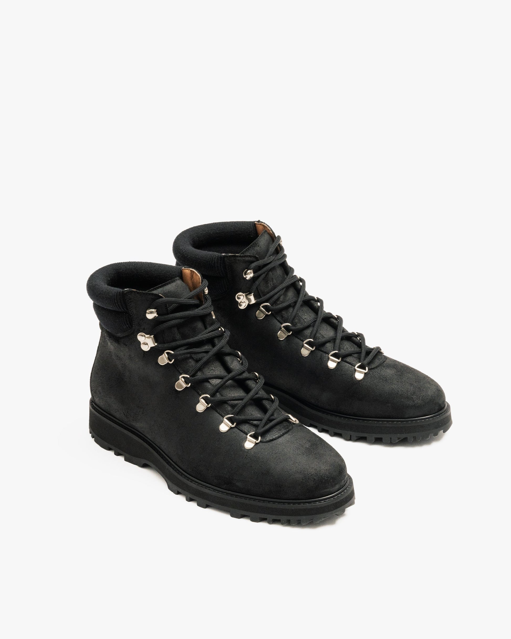 Duved in black waxed suede features water-repellent suede uppers, metal eyelets and speed hooks, padded collars, and durable hiking soles, offering a refined yet rugged look suitable for both city and outdoor wear.