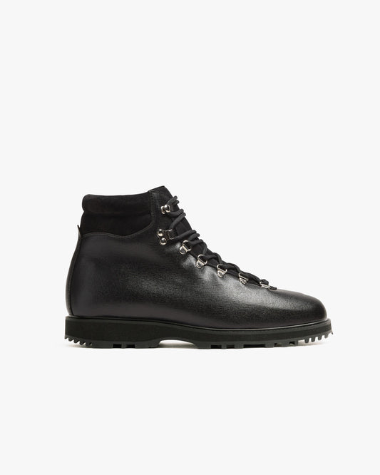 Duved boot in black grain calf features a textured leather upper, silver-toned hardware, and a padded collar, set on a rugged hiking sole for versatile city or outdoor wear.