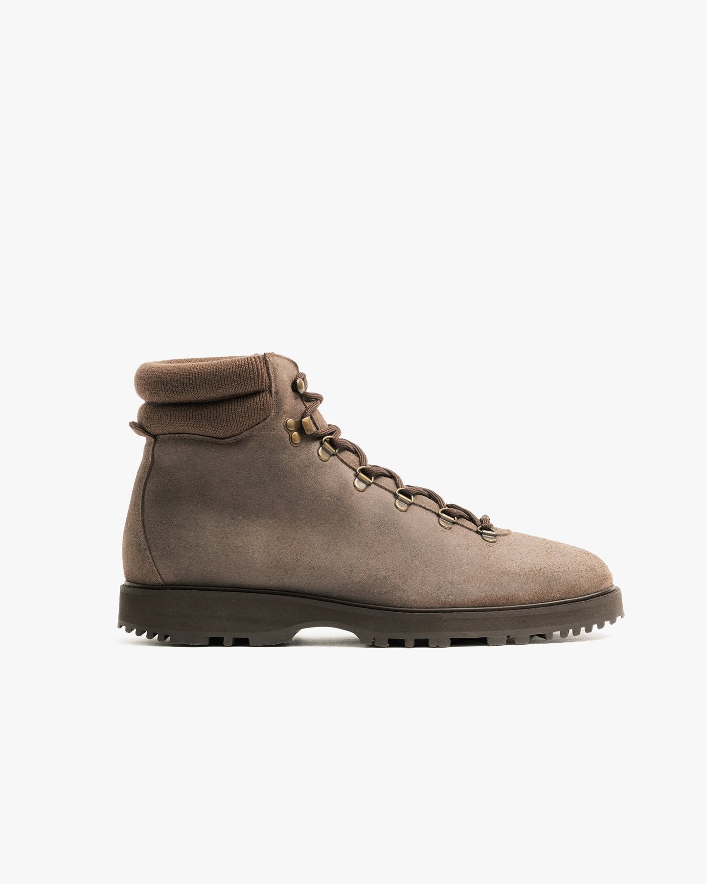 Duved in taupe waxed suede features a clean hiking boot silhouette with brass-finished hardware, a padded collar, and a rugged sole, highlighting its blend of Scandinavian design and versatile outdoor style.