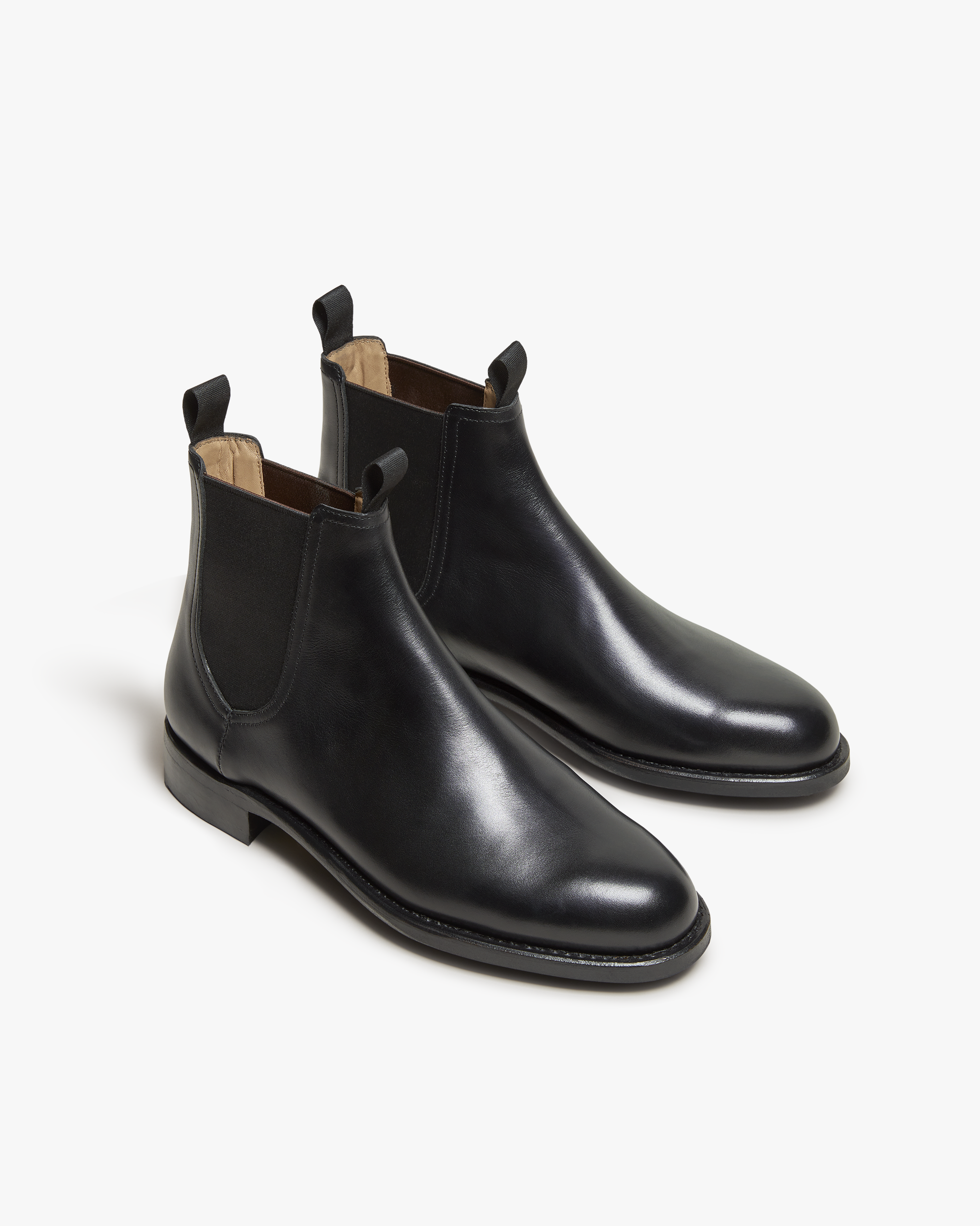 Elfvik Chelsea boots in black calf leather with a minimalist design, featuring elastic side panels, twin pull tabs, and a smooth, polished finish ideal for both formal and casual outfits.