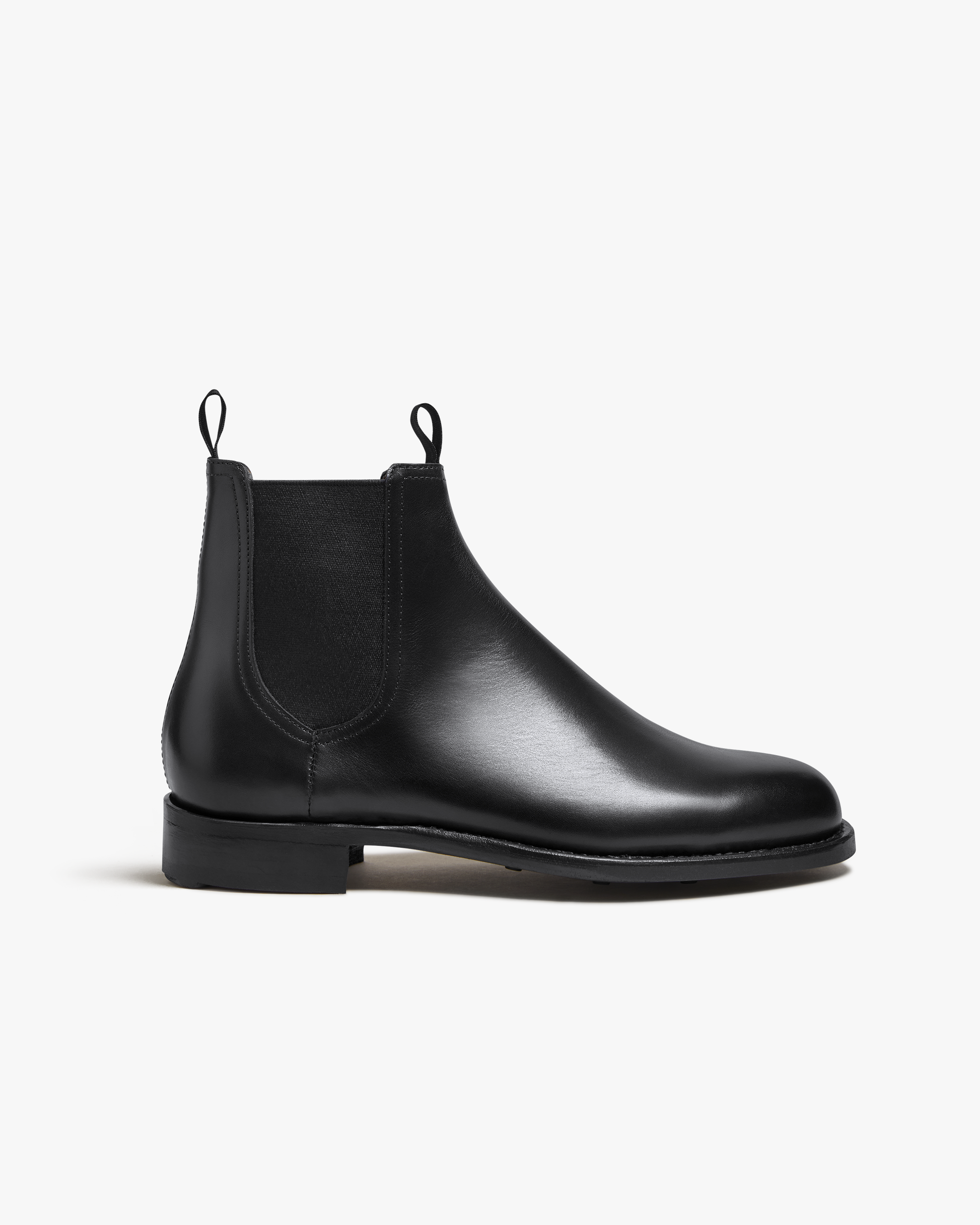 Elfvik Chelsea boot in black calf leather featuring a sleek, minimalist silhouette with elastic side panels, twin pull tabs, and a low-profile rubber sole for versatile city wear.