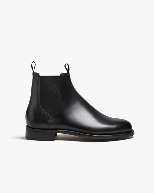 Elfvik Chelsea boot in black calf leather featuring a sleek, minimalist silhouette with elastic side panels, twin pull tabs, and a low-profile rubber sole for versatile city wear.