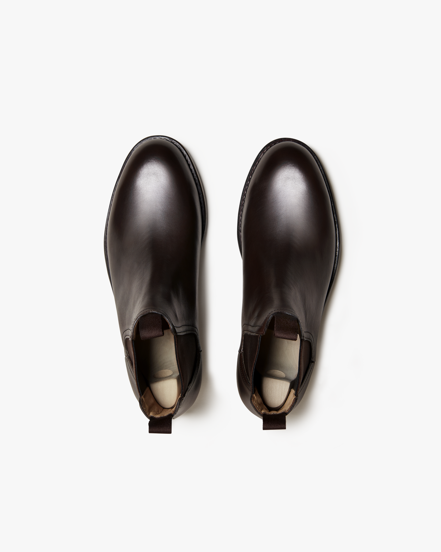 Elfvik Chelsea boots in dark brown calf leather shown from above, highlighting the smooth rounded toe, elastic side panels, and pull tabs for easy entry.