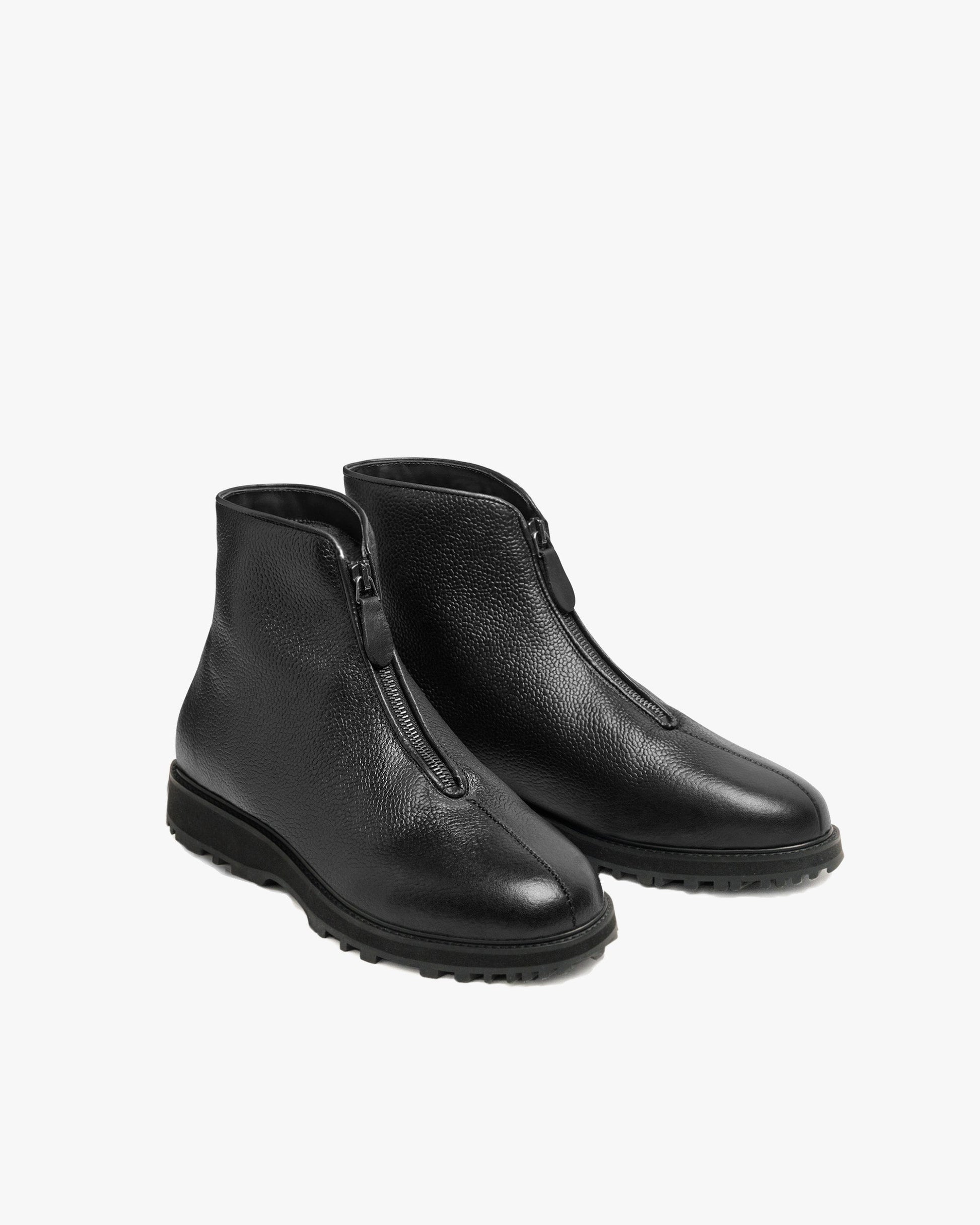 Funäs in black country calf features a pair of minimalist ankle boots with textured full-grain leather, central zippers, and sturdy Explorer soles, designed for both formal and casual winter wear.