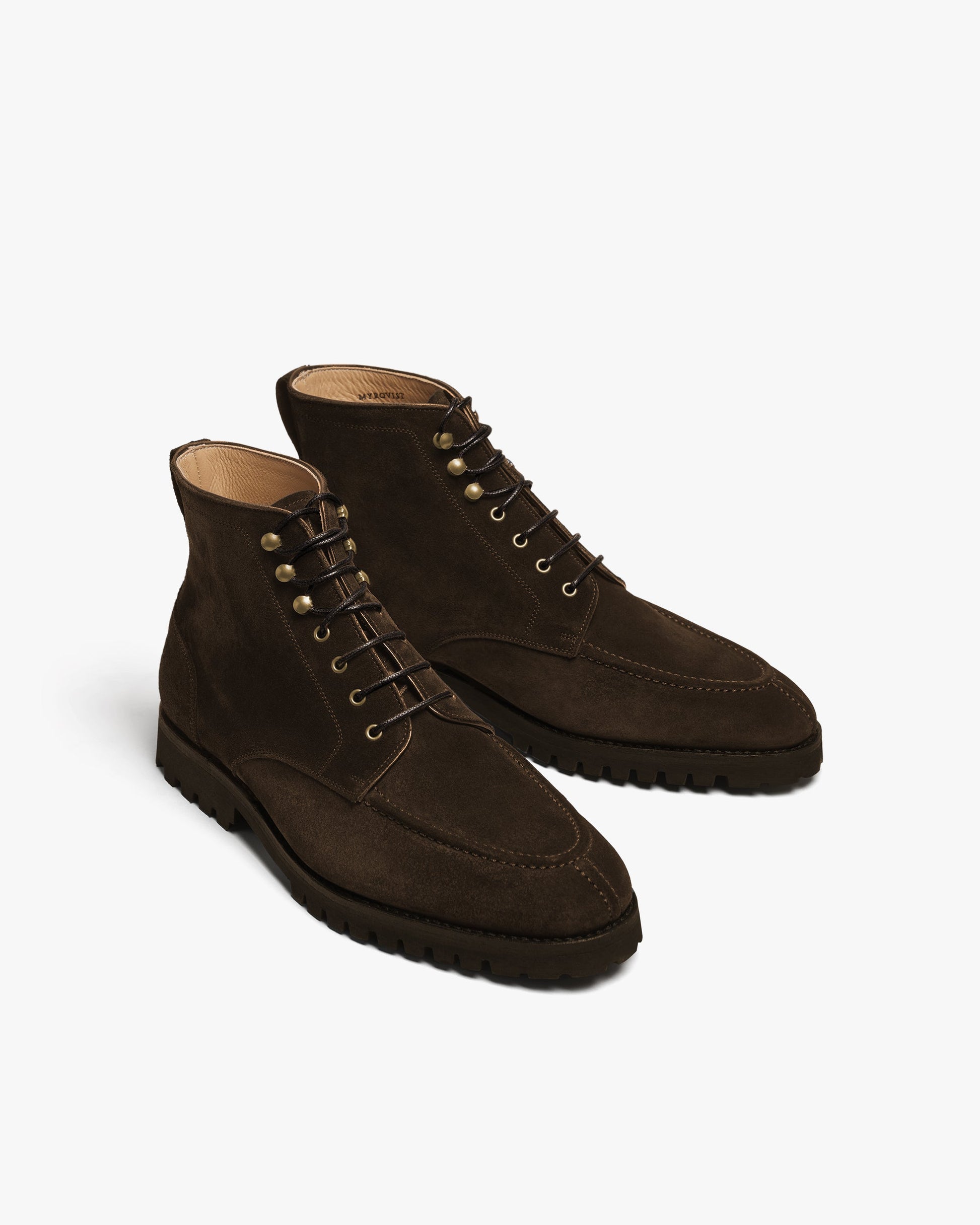 Gothem II in dark brown suede displayed at an angle, featuring a split toe apron, brass speed hooks, and a robust lug sole, with the rich suede texture and precise stitching clearly visible.