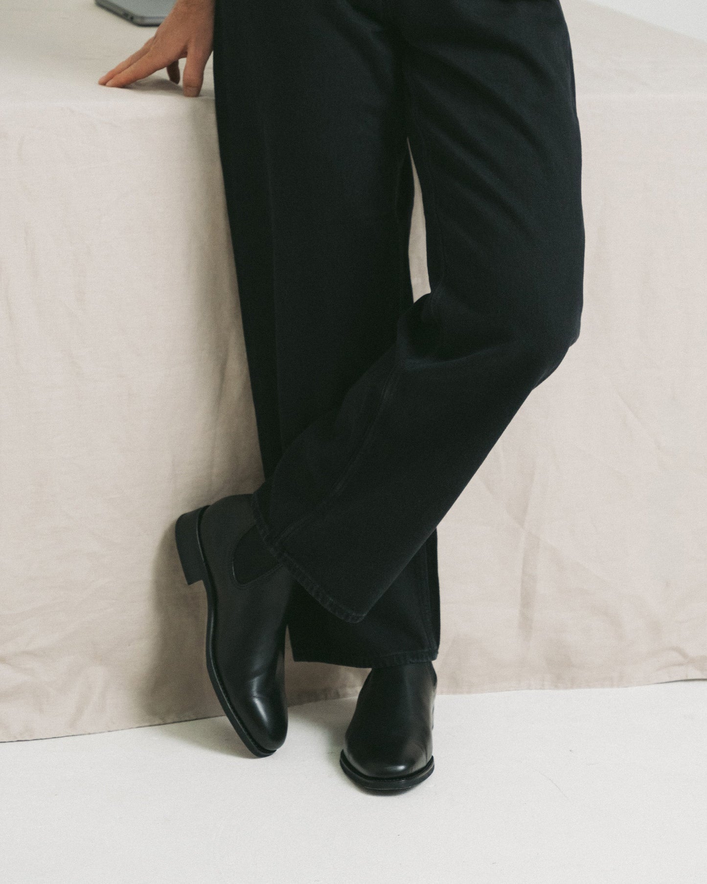Granhult in black calf styled with dark trousers, showcasing the Chelsea boot’s seamless silhouette, polished finish, and soft chisel toe in a relaxed, modern setting.