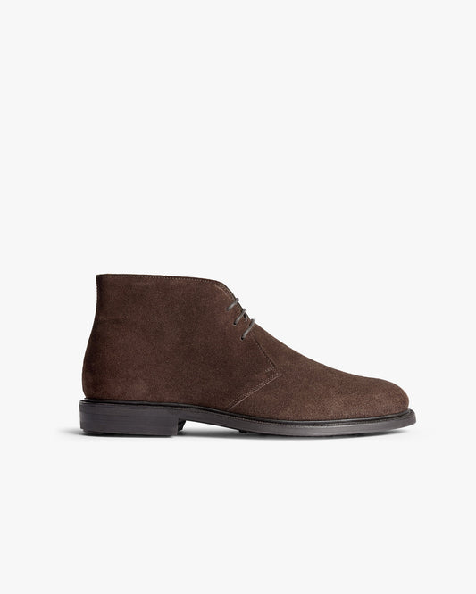 Gyllsjö II in dark brown suede shown in a classic side profile, highlighting its clean lines, soft suede texture, and understated stitching on a durable black sole. This versatile chukka boot pairs easily with tailored slacks or denim for refined everyday style.