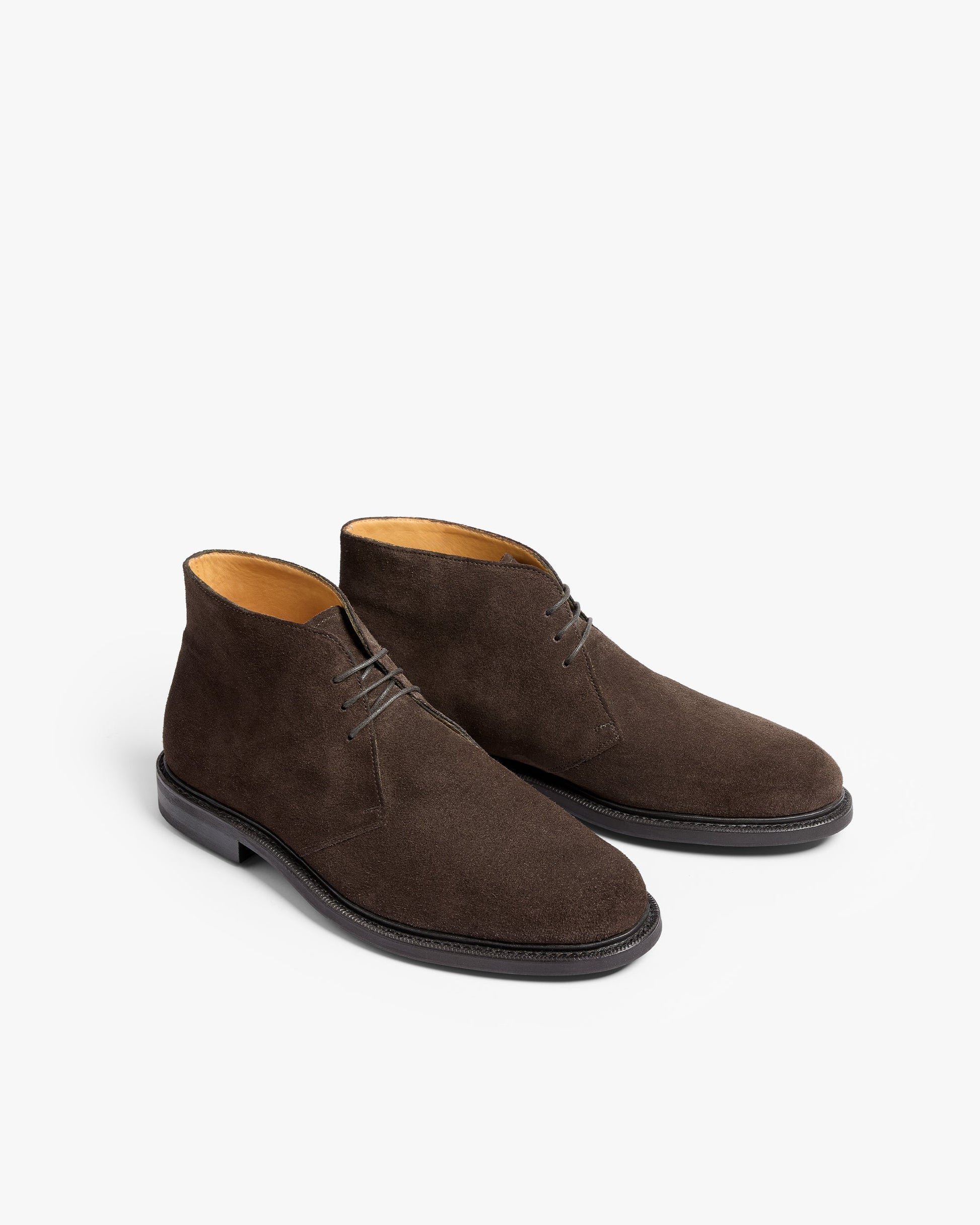Gyllsjö II in dark brown suede displayed at a three-quarter angle, featuring soft suede uppers, understated stitching, and a classic chukka boot silhouette with a softly chiseled toe and black sole.