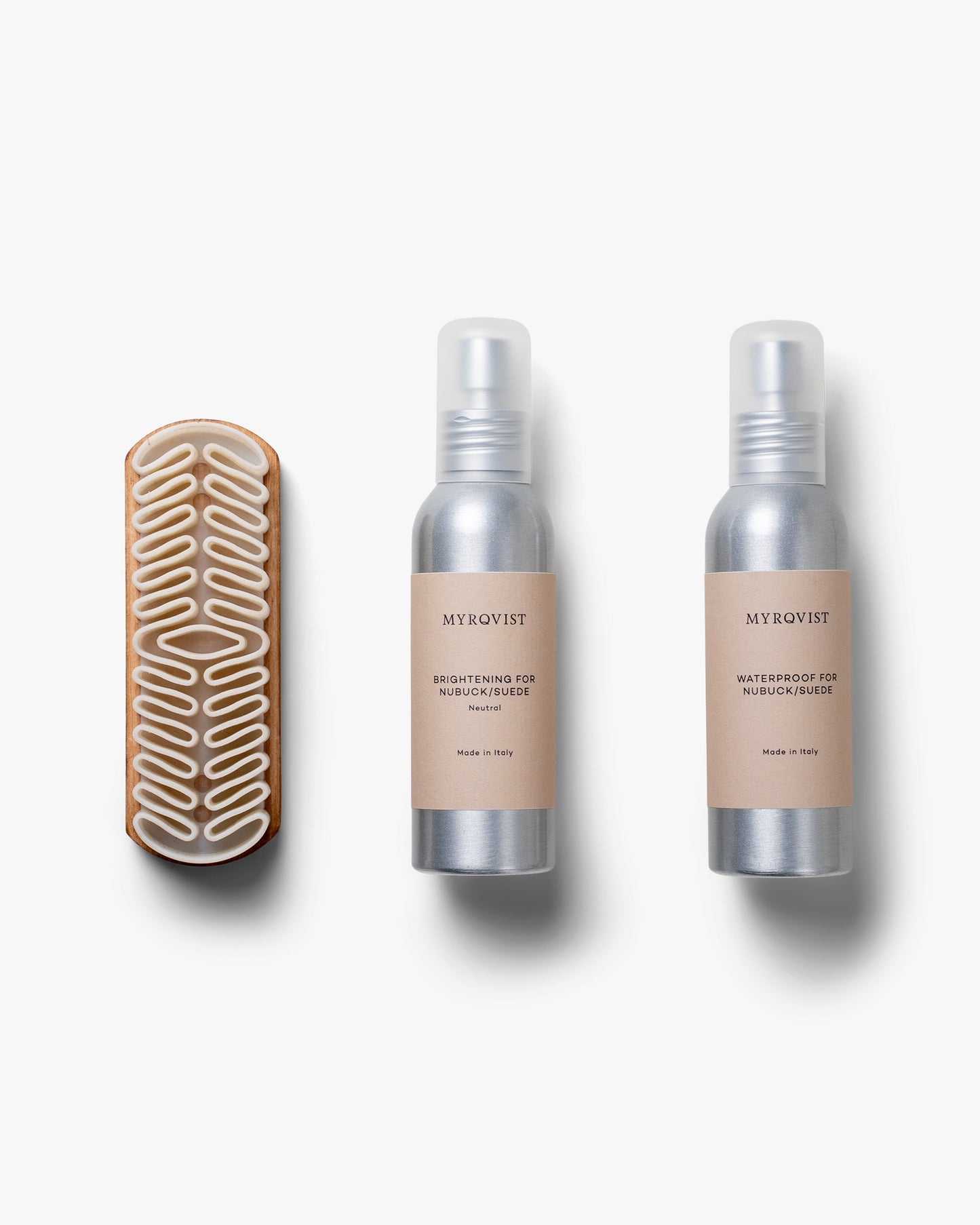 Shoe Care Kit – Suede featuring a sculpted crepe brush with a wooden handle, alongside minimalist bottles of brightening and waterproofing sprays, arranged on a clean white background.