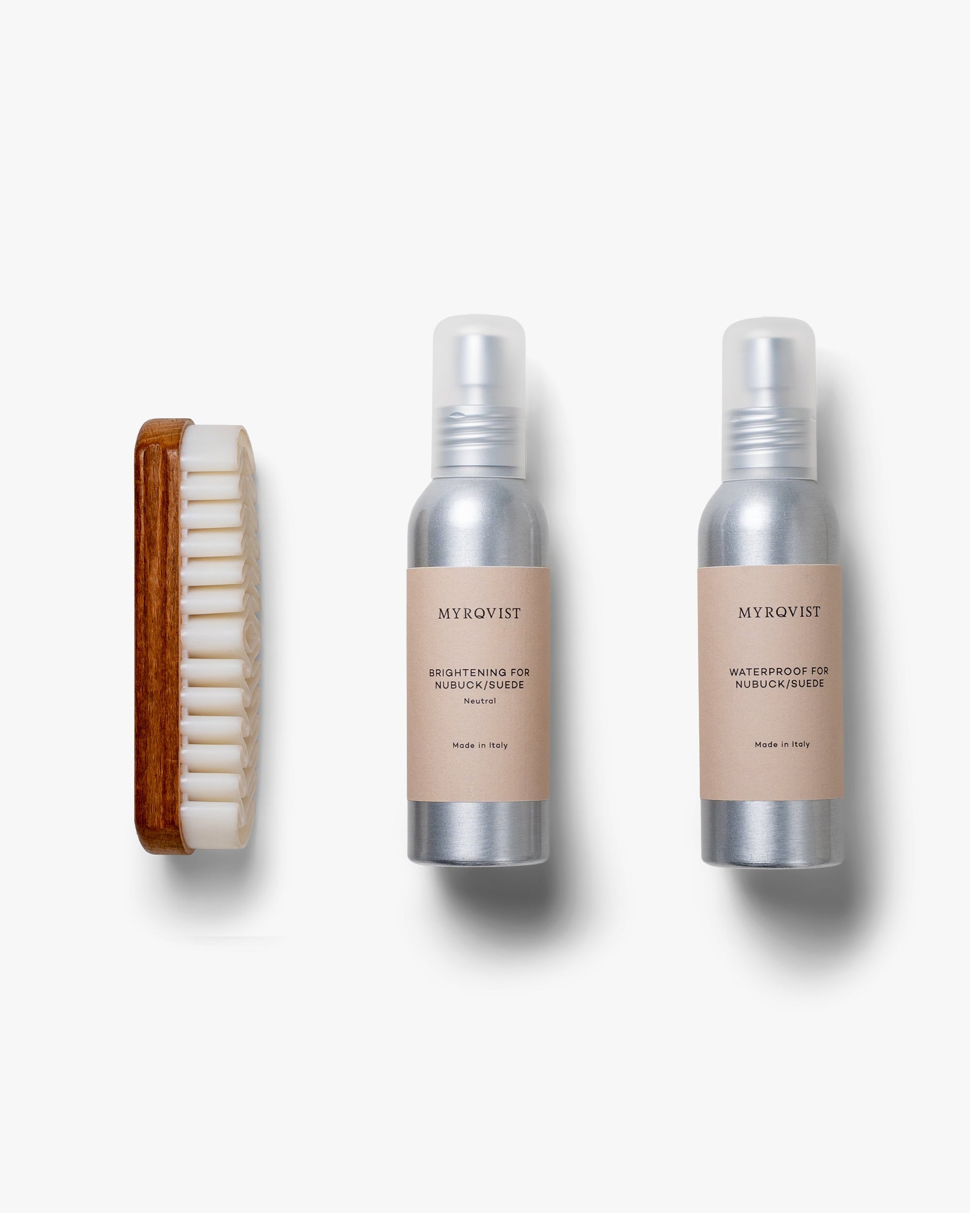 Shoe Care Kit – Suede displayed with a wooden-handled crepe brush and two minimalist bottles, one for brightening and one for waterproofing suede and nubuck shoes, set against a clean white background.