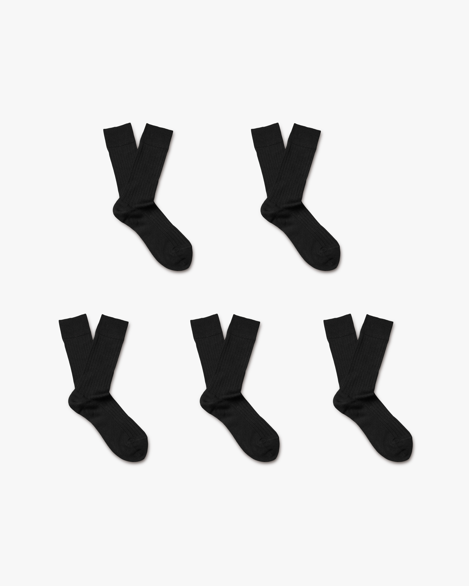 Five pairs of Ludvig merino wool socks in classic solid black, each with a ribbed, calf-high silhouette arranged neatly on a white background.
