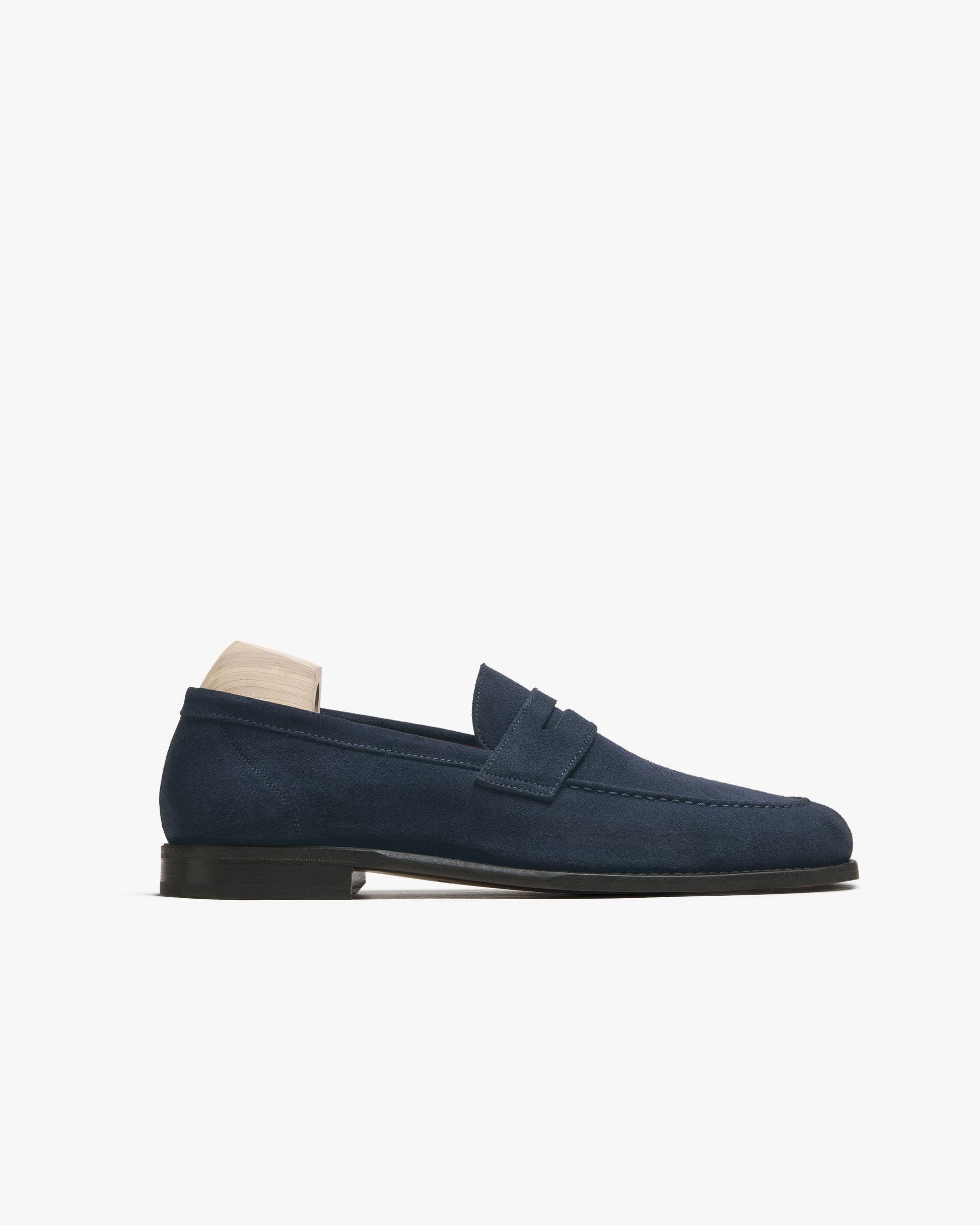 Lysekil II in navy suede features a classic penny loafer silhouette with a softly rounded toe, apron stitching, and a deep blue velvety finish, set on a slim leather sole for a refined and versatile look.