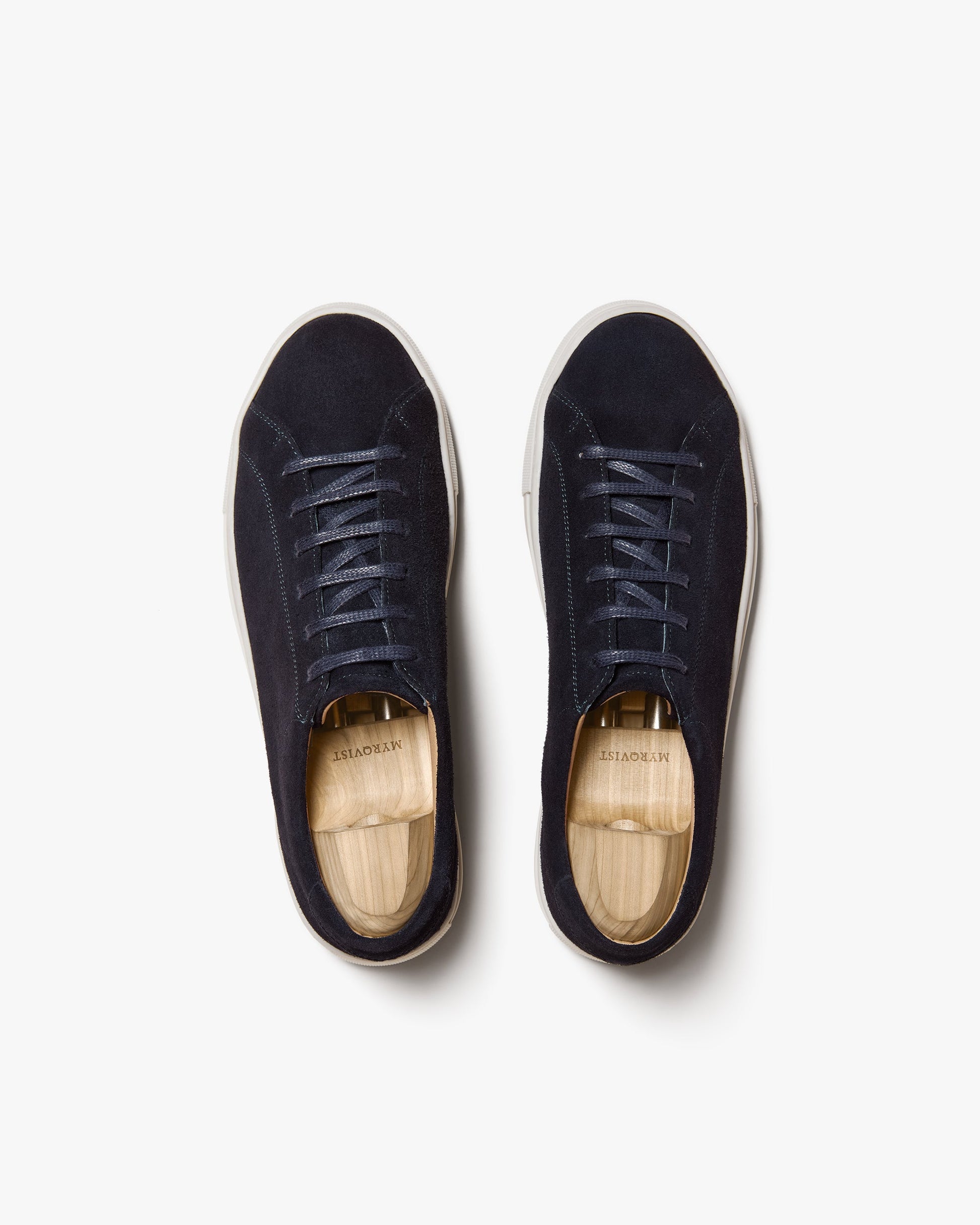 Pair of Oaxen in navy suede shown from above, featuring flat cotton laces, tonal stitching, and off-white soles, each fitted with a wooden shoe tree.