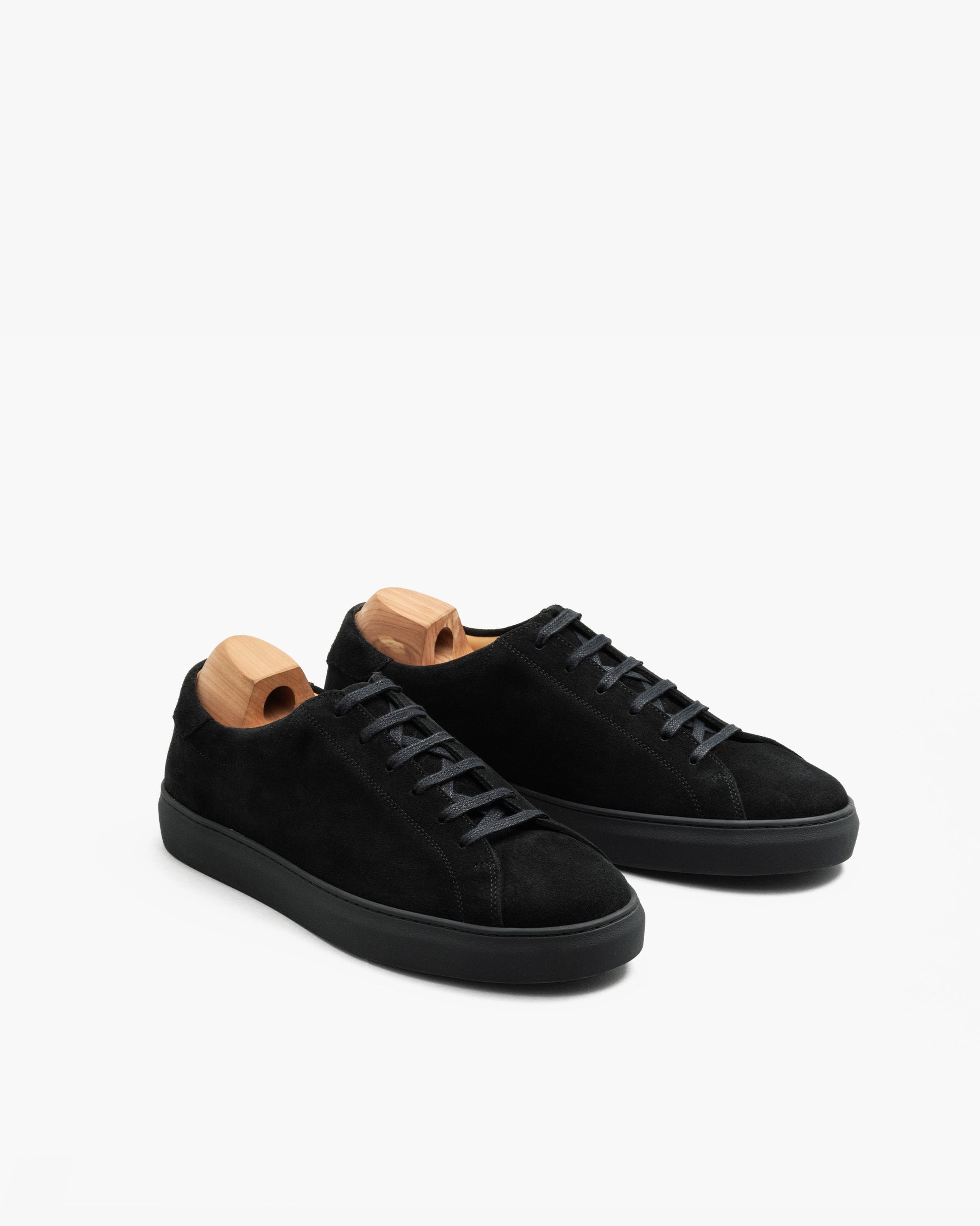 Oaxen Monochrome in black suede displayed at an angle, highlighting the minimalist silhouette, tonal laces, matte suede finish, and wooden shoe trees for shape retention.