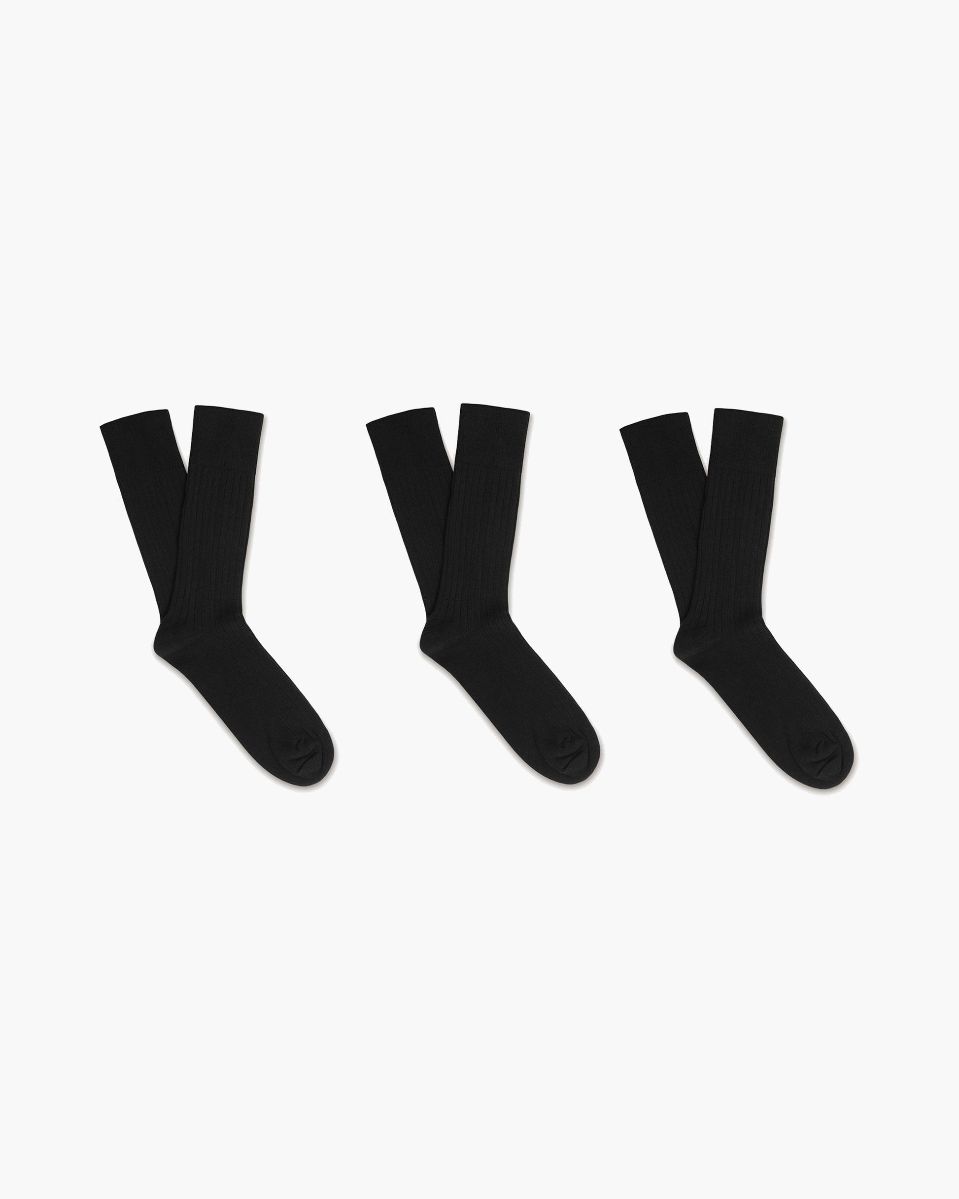 Three pairs of Oscar – Cotton Socks in black, laid flat on a white background.