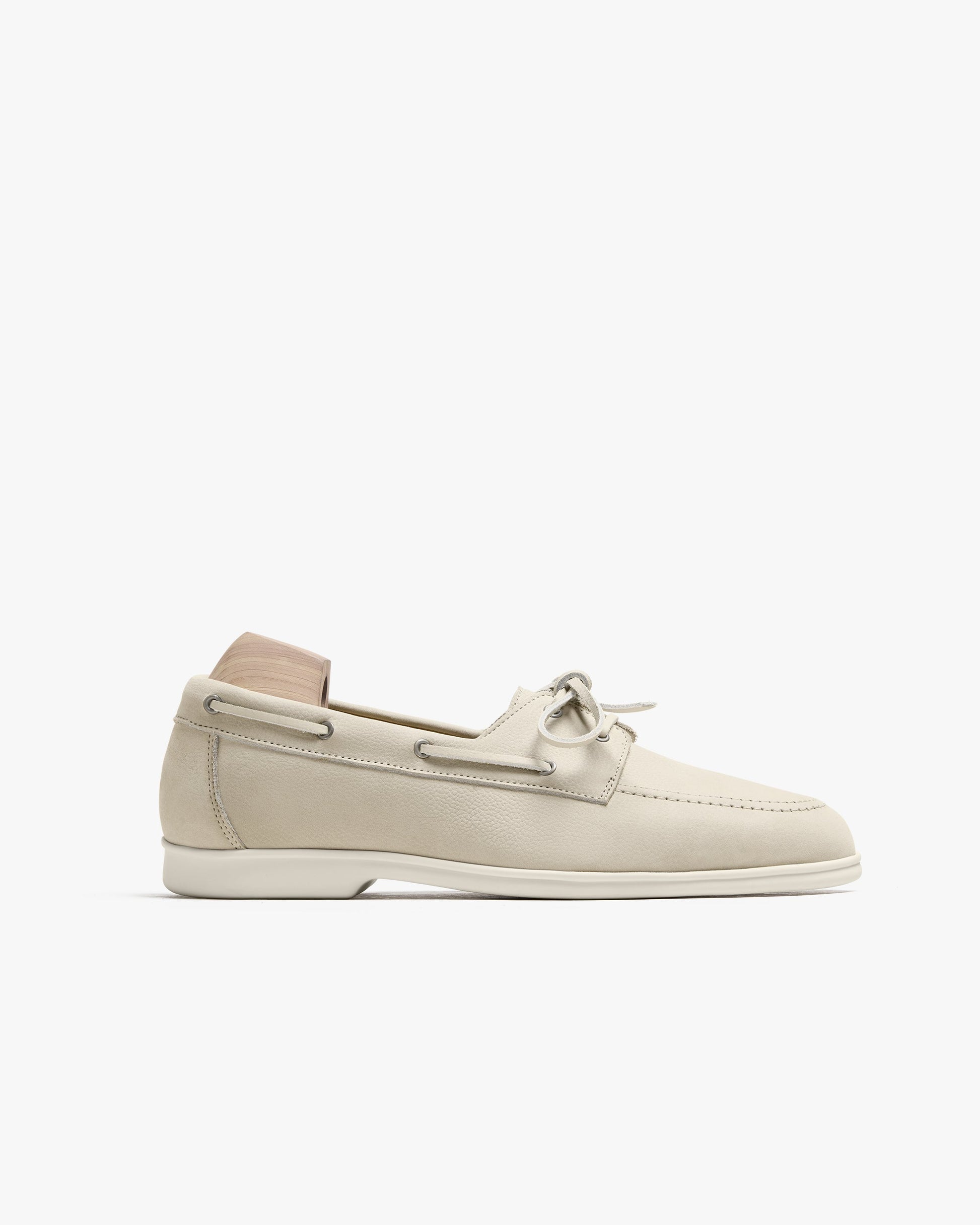 Sandhamn in beige nubuck features a classic boat shoe silhouette with soft nubuck leather, hand-stitched seams, and minimalist lacing, set on a pale sole for a fresh, contemporary look. The shoe is shown in profile, highlighting its relaxed fit and refined Scandinavian-inspired design.