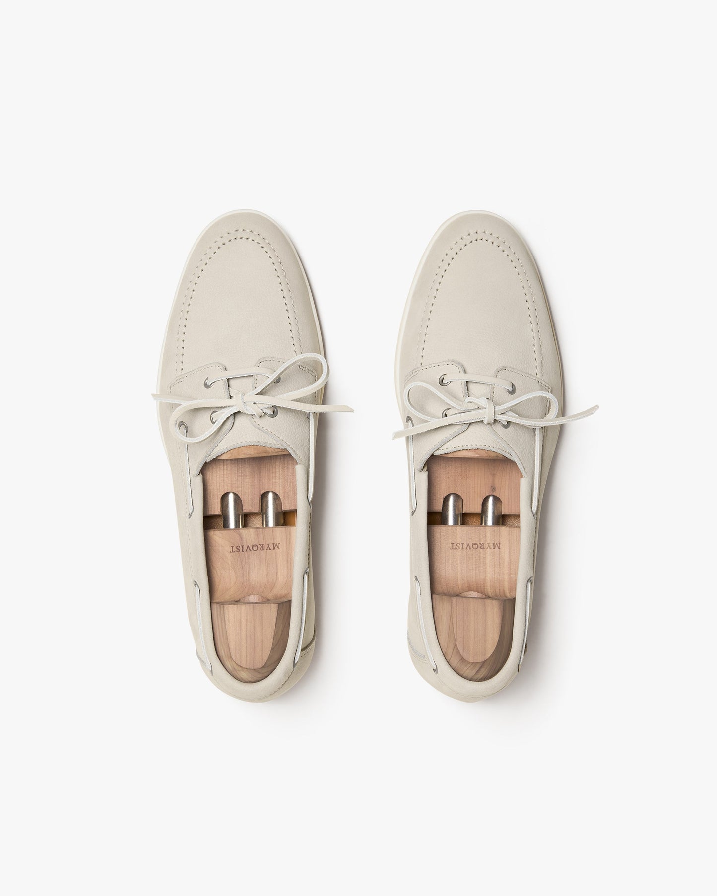 Sandhamn in beige nubuck shown from above, highlighting the soft nubuck upper, hand-stitched seams, minimalist lacing, and included wooden shoe trees for maintaining shape and structure.