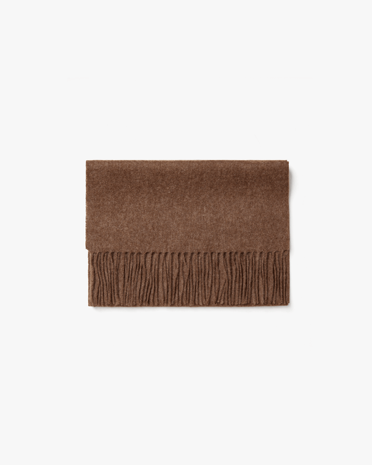 A flat lay of the Wool Scarf – Taupe, folded on a white background to showcase its texture and fringed edge.