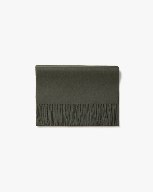 The Wool Scarf – Dark Green, neatly folded to display its texture and fringed edge against a white background.