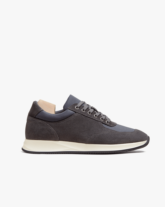 Stensund in dark grey suede features a softly contoured silhouette with tonal mesh panels, a lace-up closure, and a lightweight off-white rubber sole, blending athletic comfort with understated Scandinavian style.