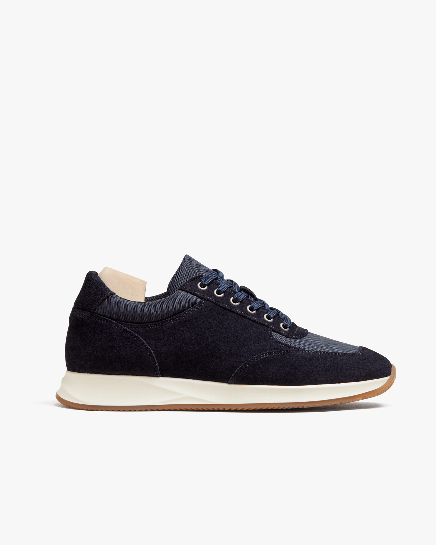 Stensund in navy suede features a sleek, low-profile silhouette with deep navy suede and tonal mesh panels, set on a natural-toned rubber sole with a gum outsole for a refined, athletic look. The lace-up trainer is shown in a side view, highlighting its softly contoured lines and versatile styling.